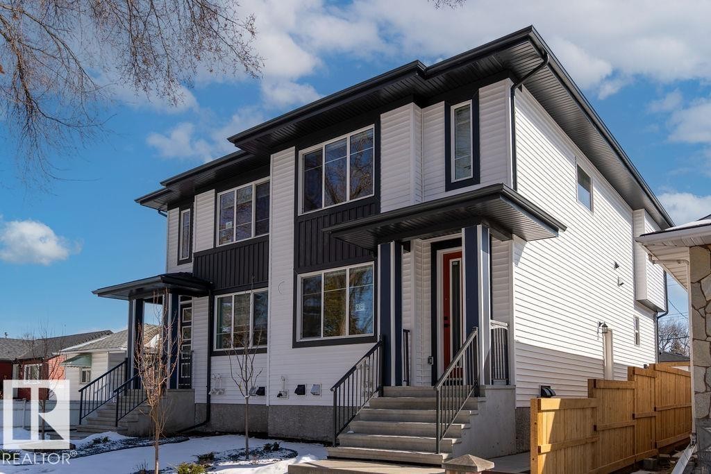 The property features a contemporary exterior with white siding and dark accents, multiple windows, and a red front door - 12307 91 St Nw, Edmonton, AB - Outdoor