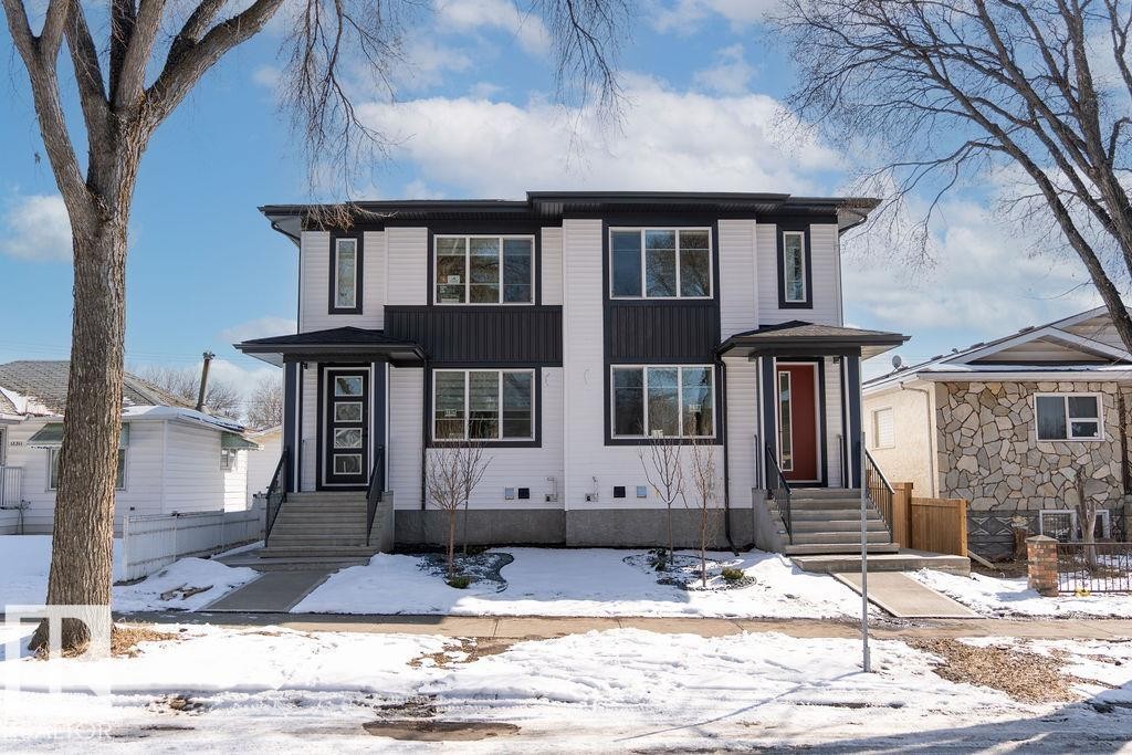 The property features a modern exterior with white siding and dark accents, including black window frames and a contrasting dark paneling on the second level - 12307 91 St Nw, Edmonton, AB - Outdoor With Facade