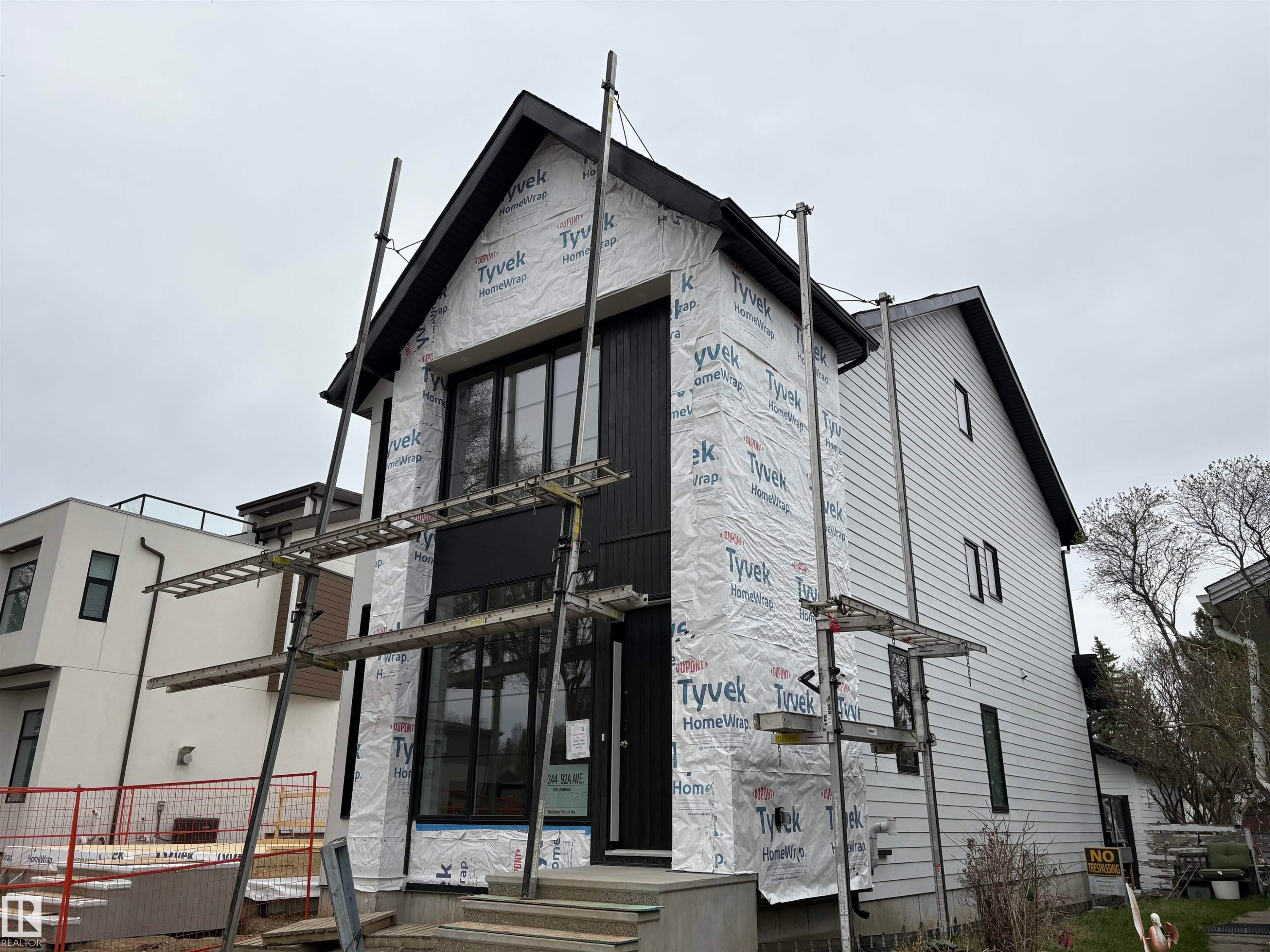 Contemporary architectural design featuring dark vertical siding and a prominent gabled roofline - 14344 92A Avenue, Edmonton, AB - Outdoor