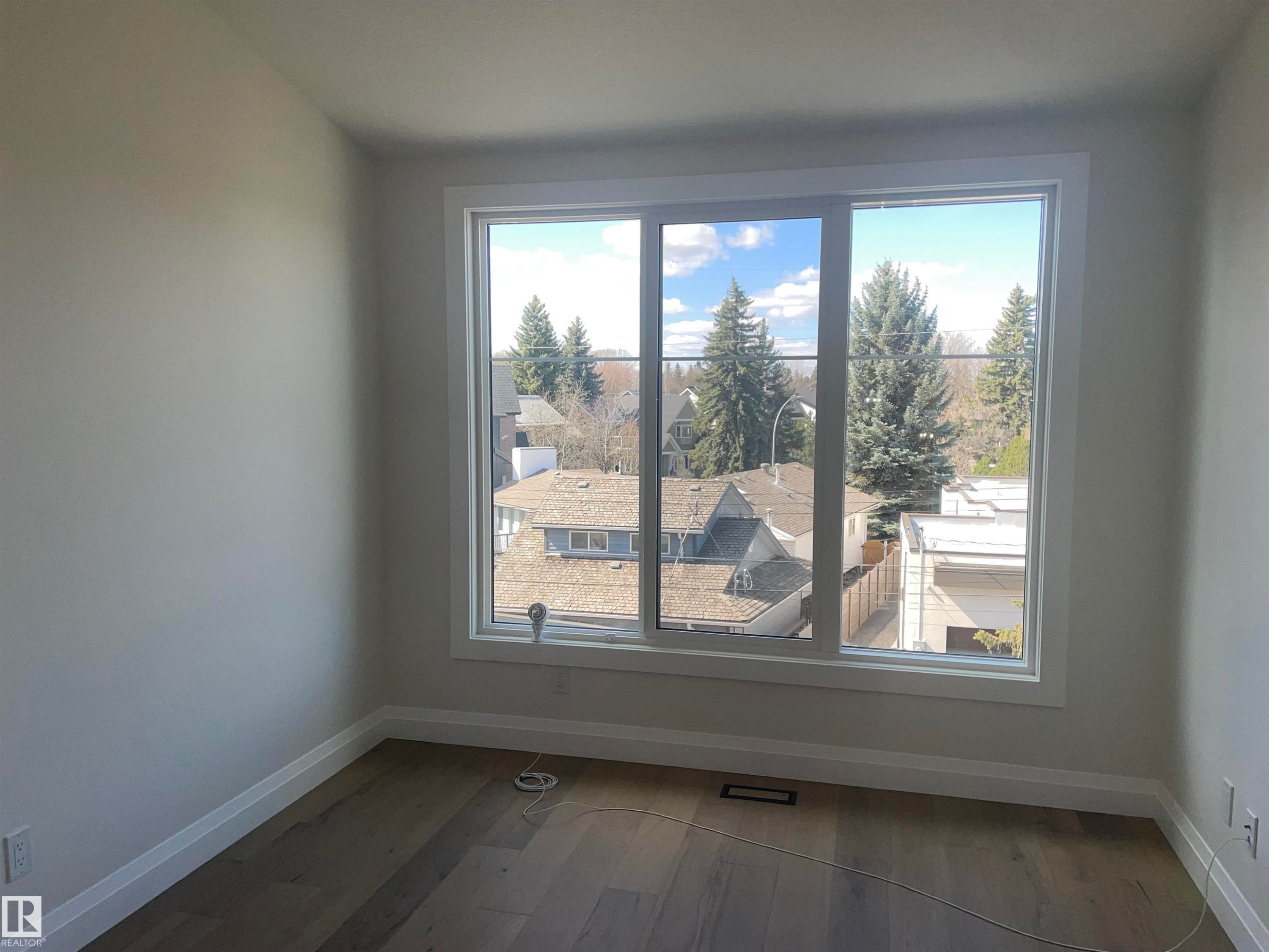 Contemporary room featuring an elongated linear fireplace, built-in shelving, two vertical windows with white trim, recessed ceiling lighting, and wood-finish flooring - 14344 92A Avenue, Edmonton, AB - Indoor Photo Showing Living Room With Fireplace