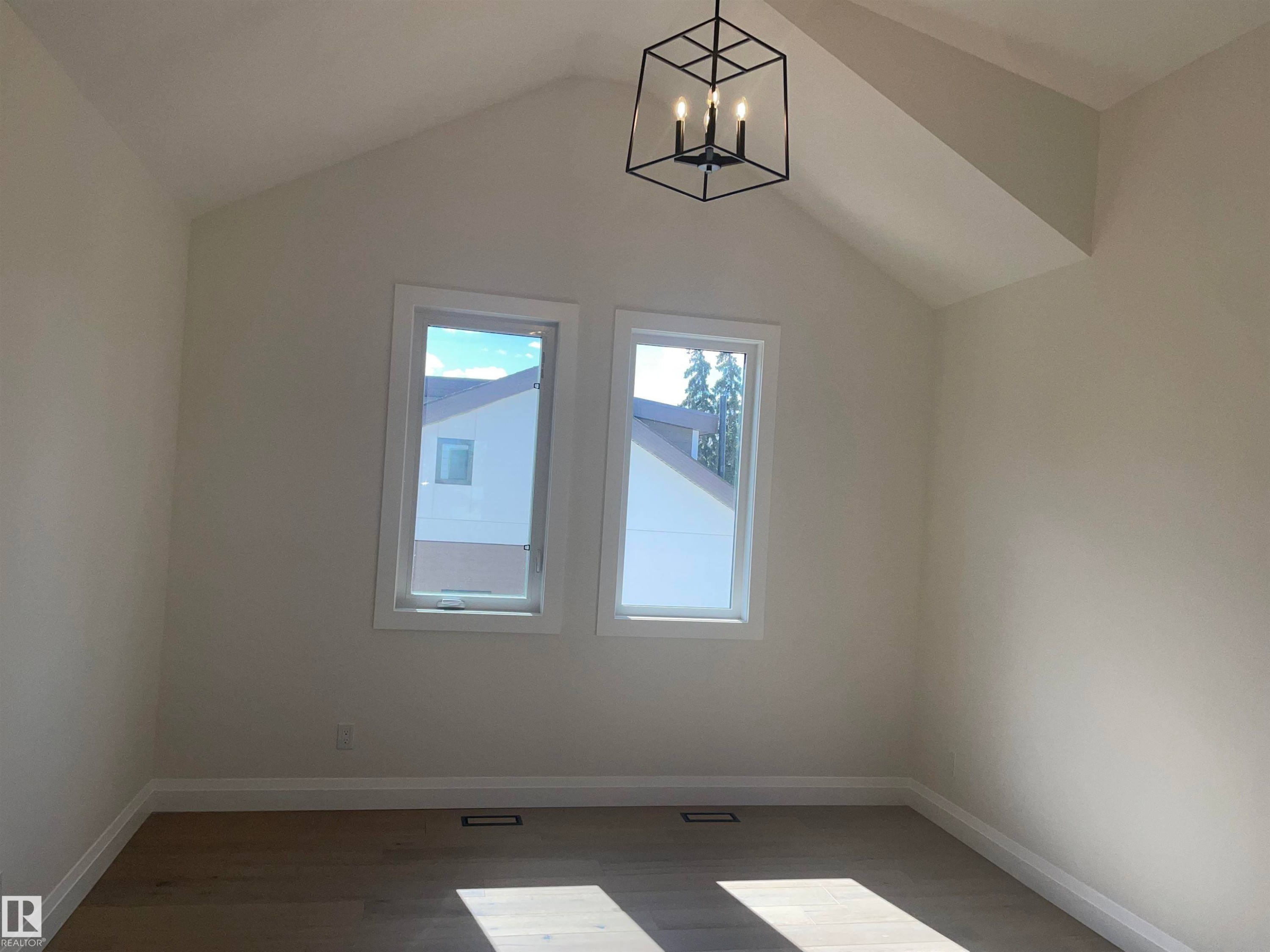 Upper-level landing featuring light wood-finish flooring, a dark metal balustrade, and a contemporary chandelier - 14344 92A Avenue, Edmonton, AB - Indoor Photo Showing Other Room