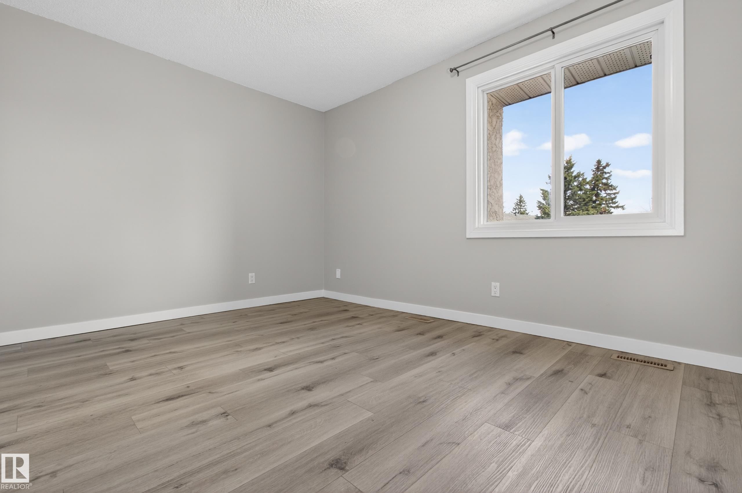 Room featuring light gray walls, white trim, and wood-finish flooring - 18 Lakewood Village, Edmonton, AB - Indoor Photo Showing Other Room