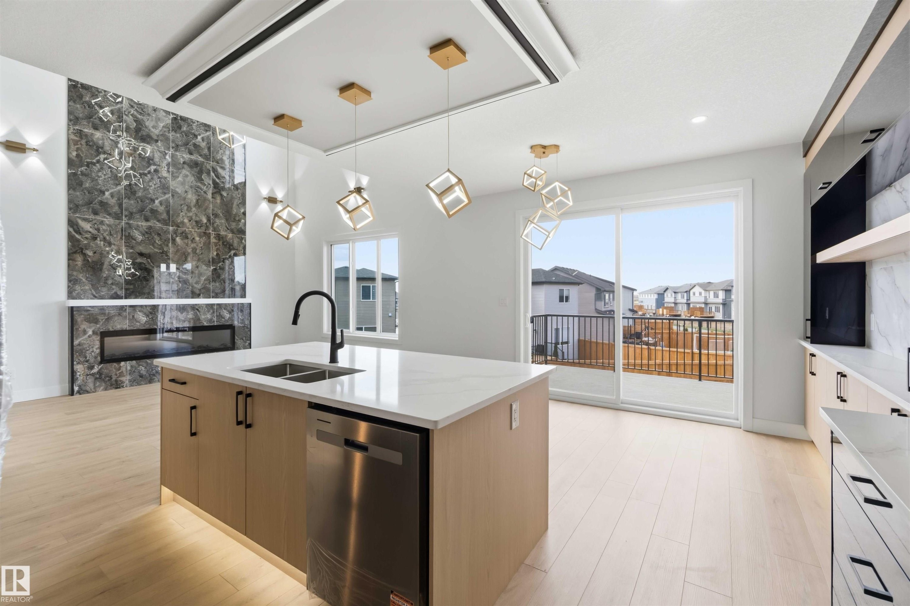 Open-concept interior featuring light wood-finish flooring, a kitchen island with a quartz countertop, and stainless steel appliances - 417 Pine Point(E), Leduc, AB - Indoor Photo Showing Kitchen With Double Sink With Upgraded Kitchen