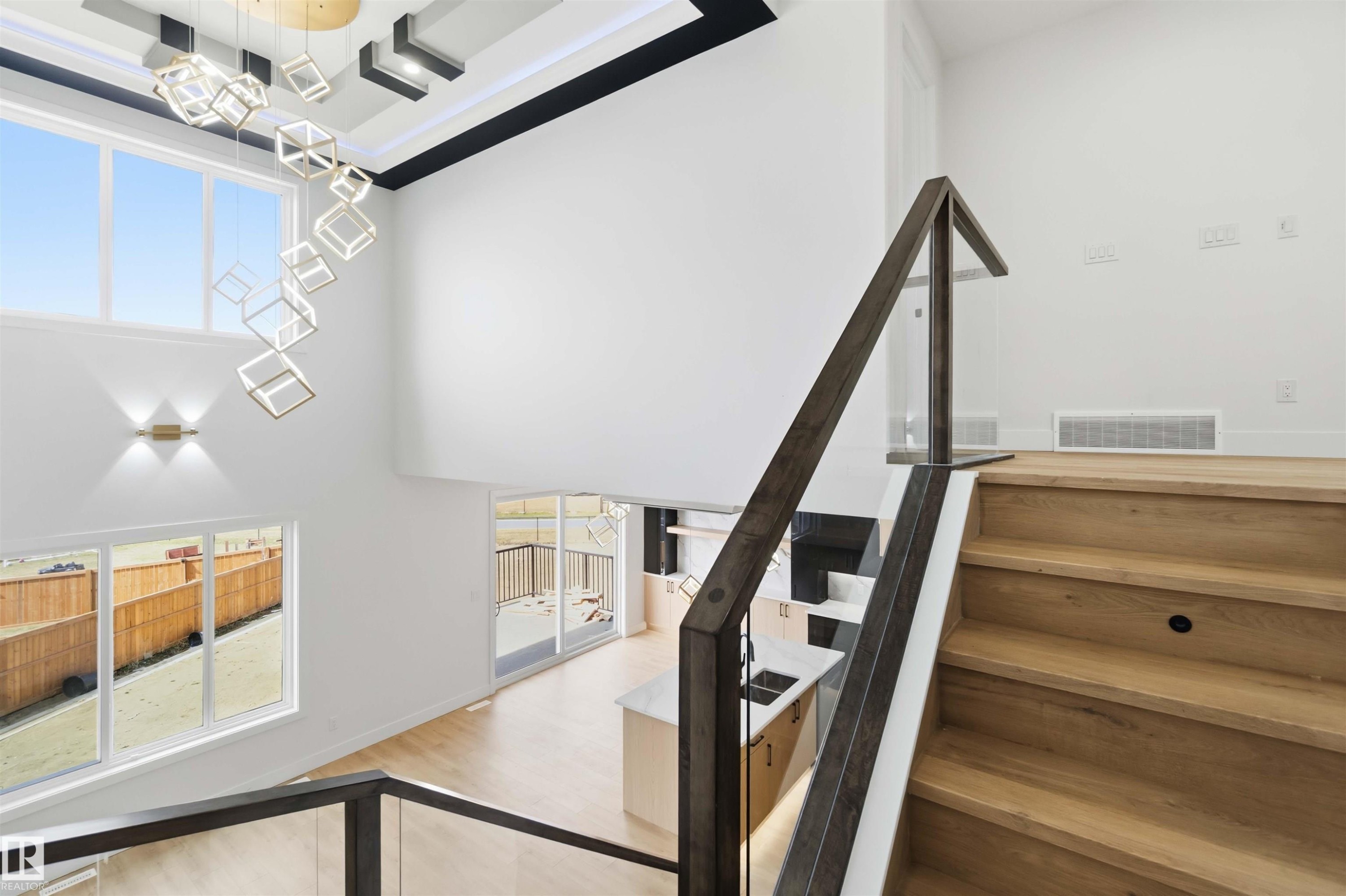 Grand foyer featuring a multi-story ceiling with contemporary chandelier and dual-pane windows - 417 Pine Point(E), Leduc, AB - Indoor Photo Showing Other Room