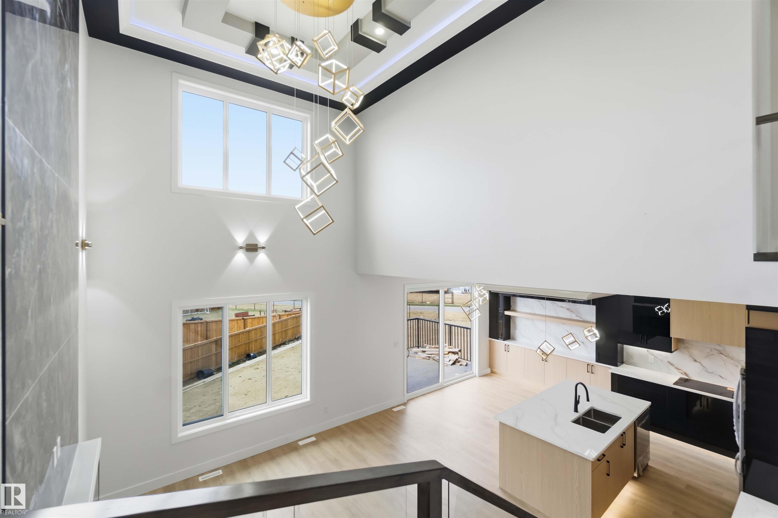 Two-story living area with high ceilings, contemporary chandelier, and light wood-finish flooring - 417 Pine Point(E), Leduc, AB - Indoor