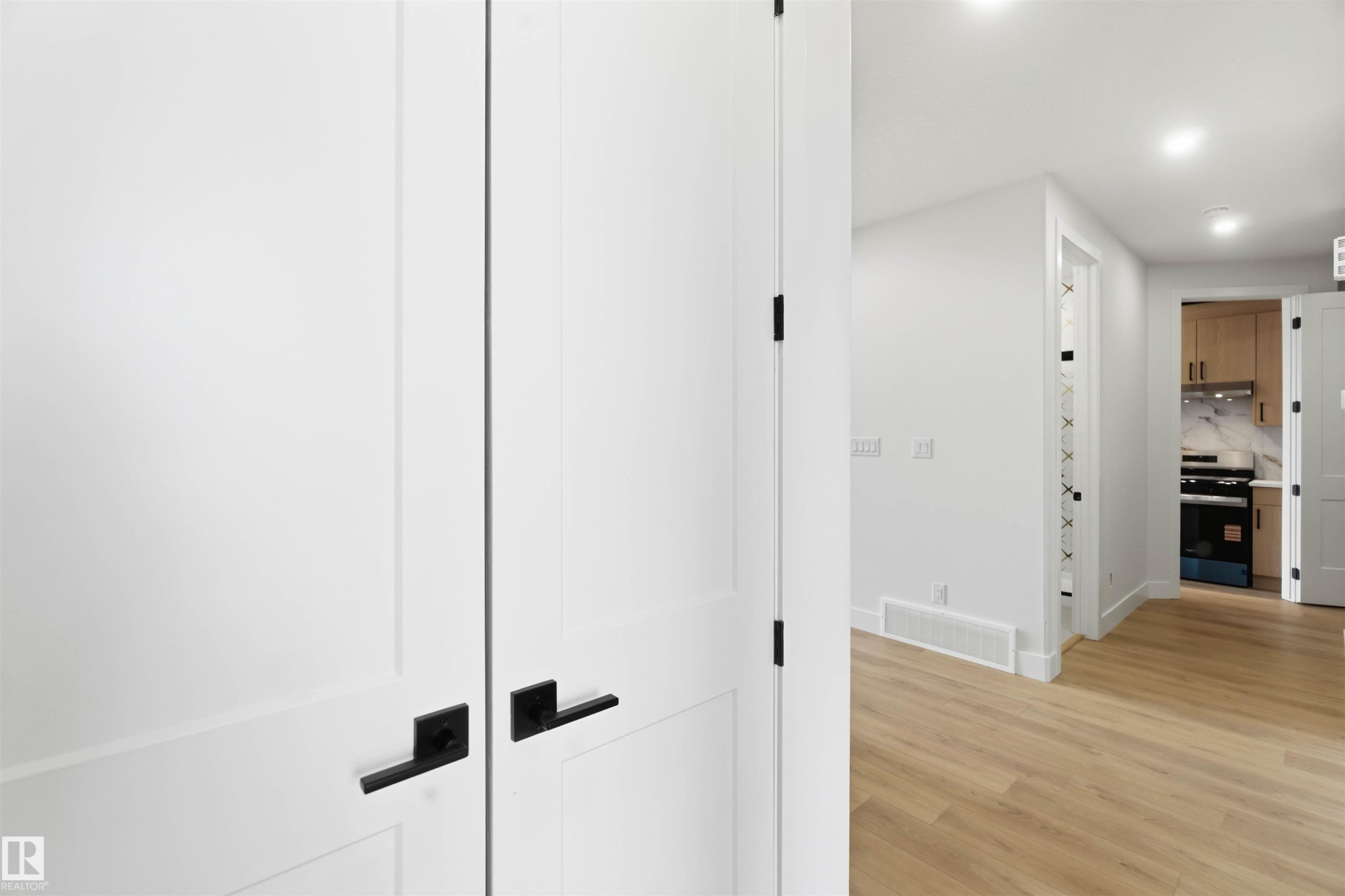 White paneled doors with matte black hardware - 417 Pine Point(E), Leduc, AB - Indoor Photo Showing Other Room