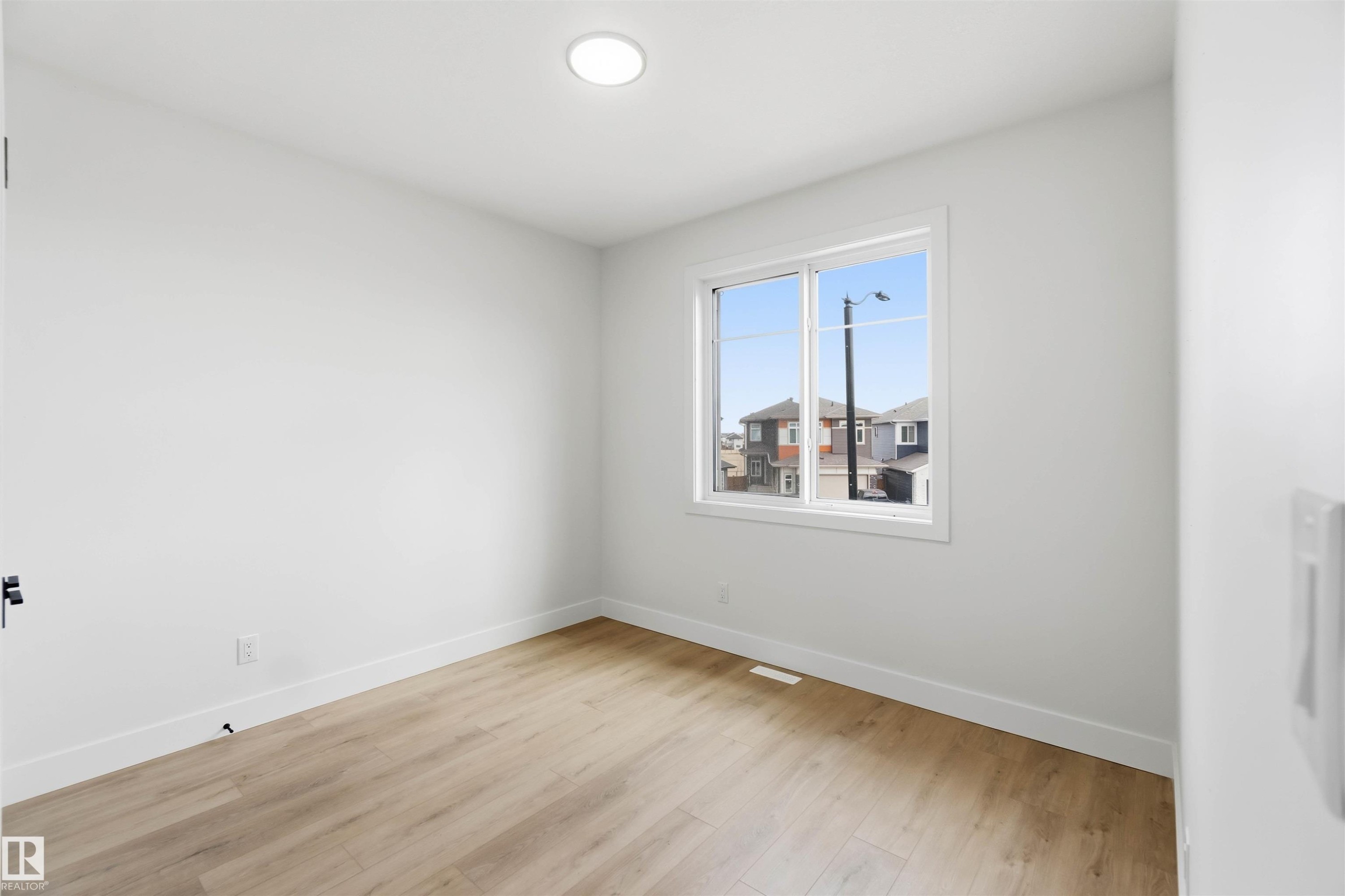 Room featuring light wood-finish flooring, white walls, and bright baseboards - 417 Pine Point(E), Leduc, AB - Indoor Photo Showing Other Room