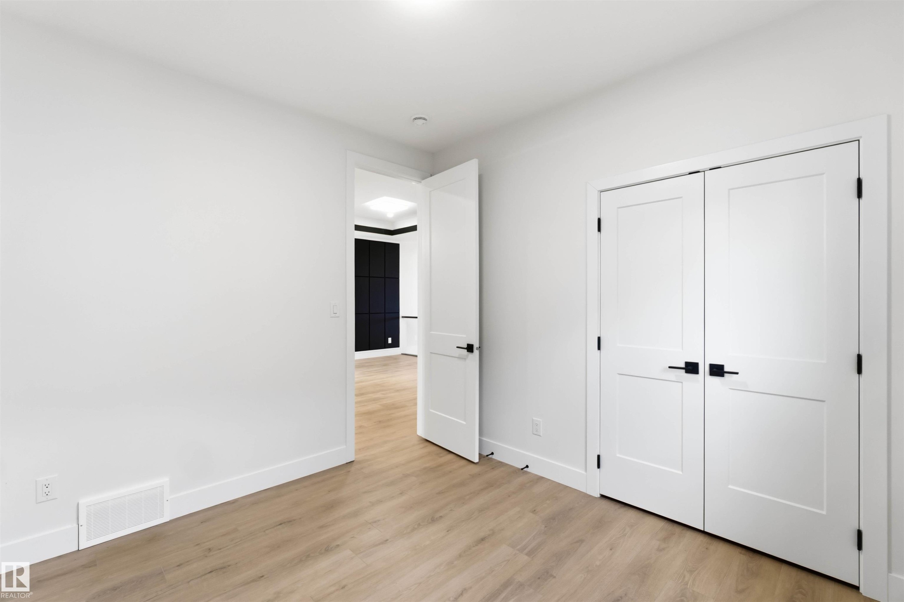 Interior room featuring neutral wall paint, light wood-finish flooring, and white baseboards - 417 Pine Point(E), Leduc, AB - Indoor Photo Showing Other Room