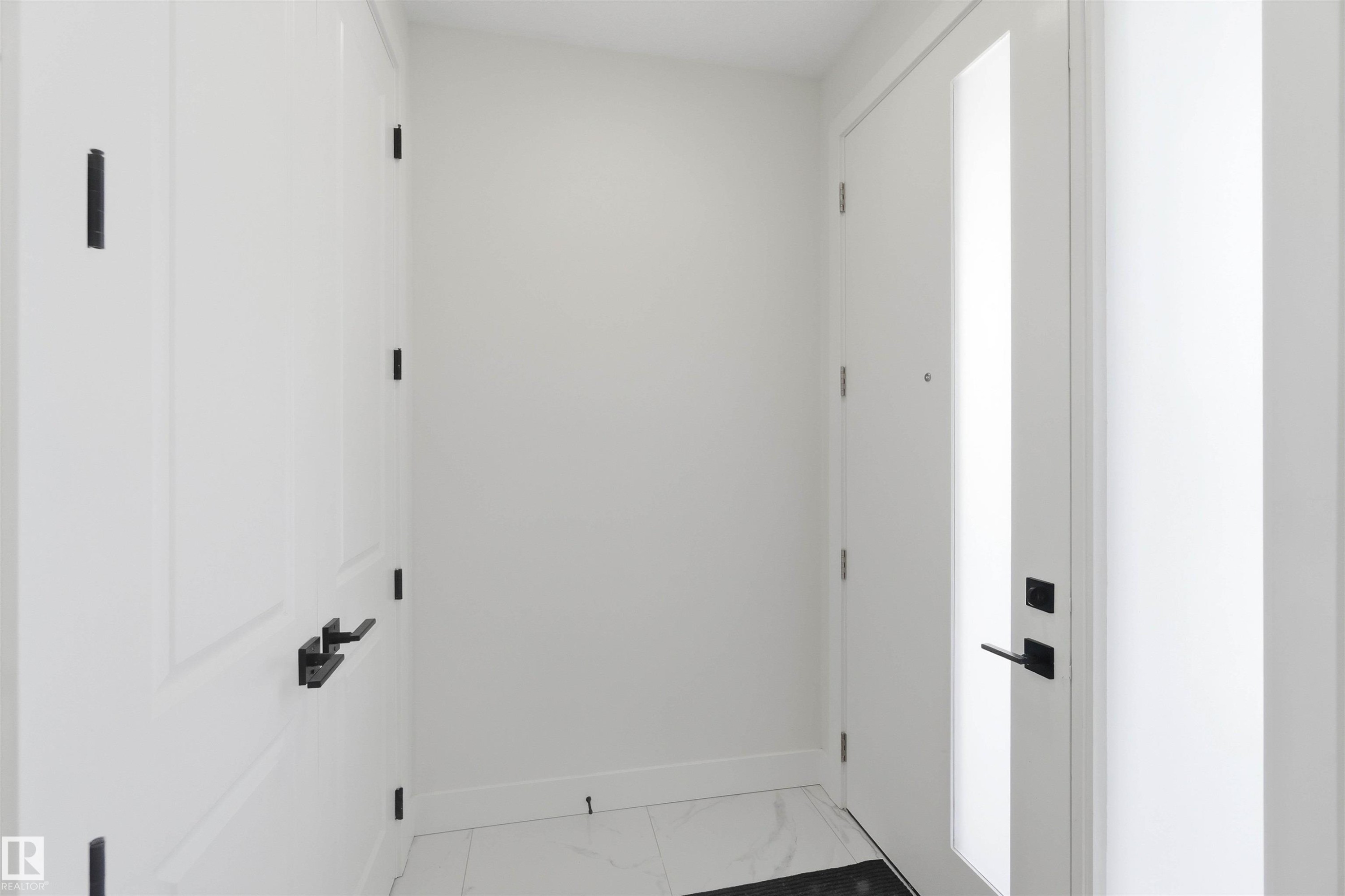 Entryway featuring a white paneled door with matte black hardware, a frosted glass sidelight, and white tile flooring - 415 Pine Point(E), Leduc, AB - Indoor Photo Showing Other Room