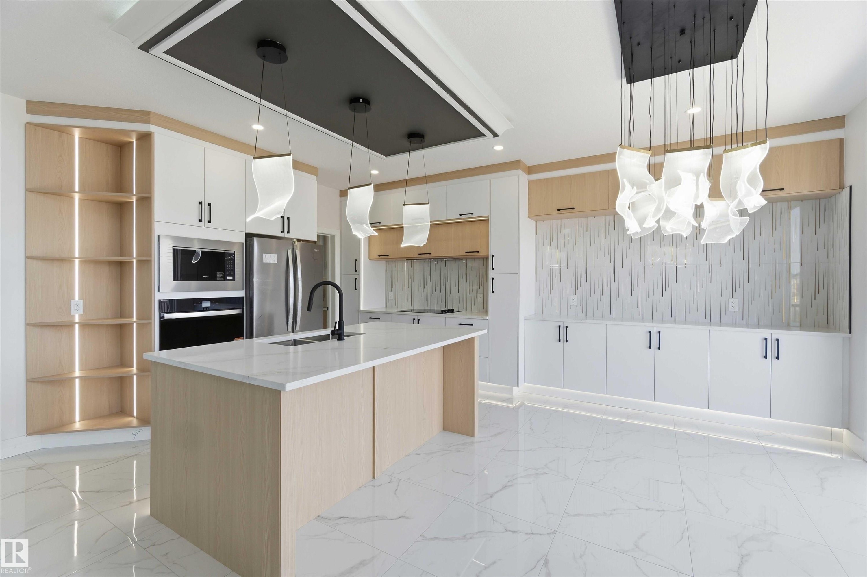 Contemporary kitchen featuring a large center island with a light-toned wood-finish base and a light-toned countertop - 415 Pine Point(E), Leduc, AB - Indoor Photo Showing Kitchen With Upgraded Kitchen
