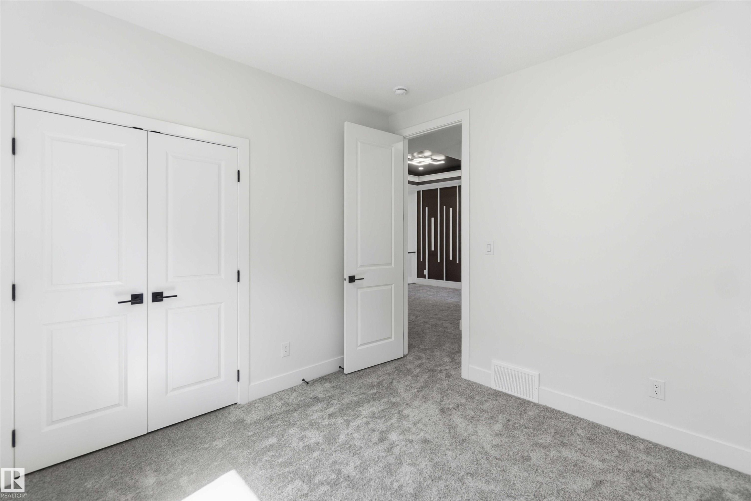 Neutral white walls throughout this space with a plush grey carpet - 415 Pine Point(E), Leduc, AB - Indoor Photo Showing Other Room