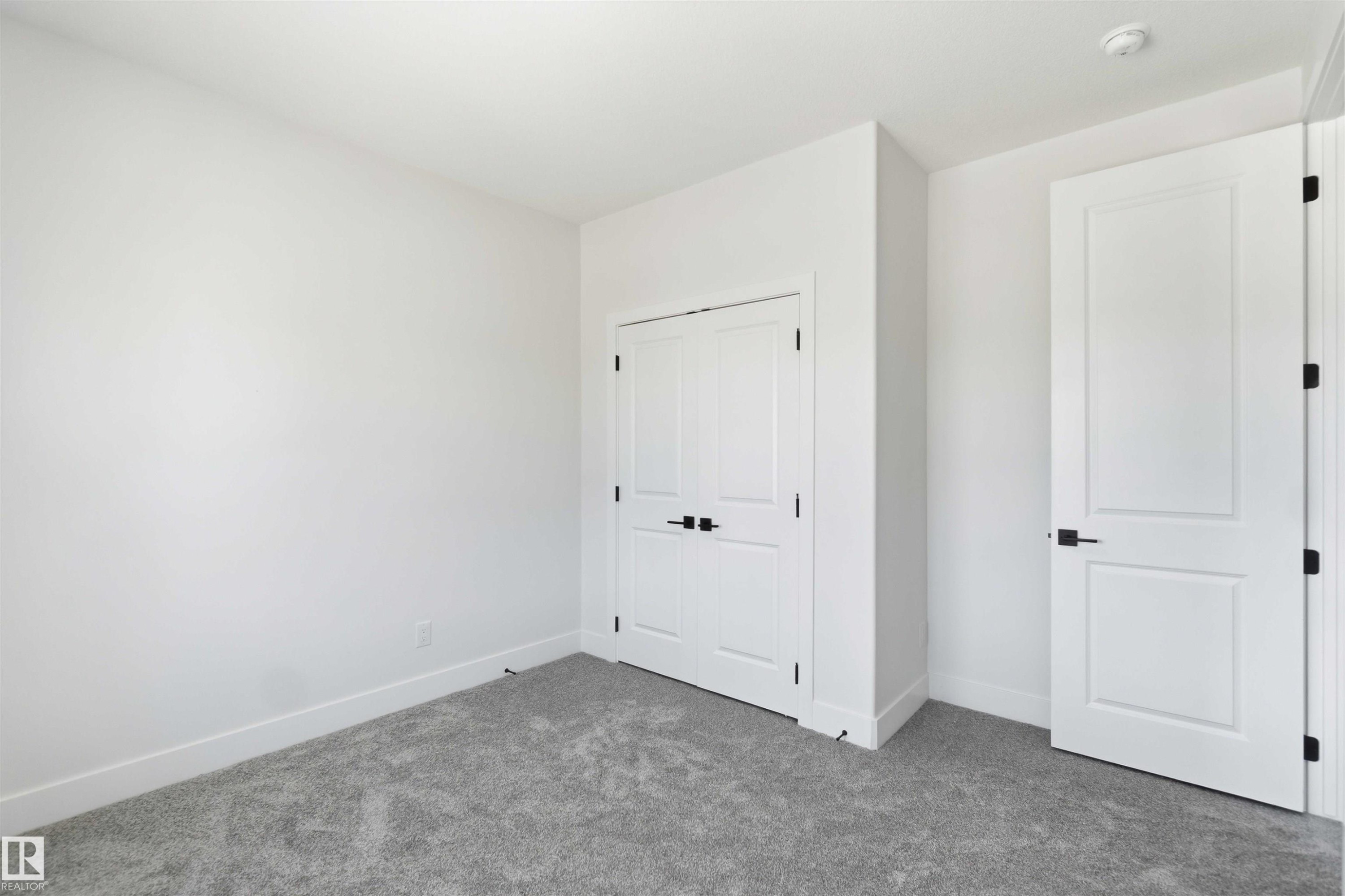 Spacious room featuring neutral carpeting, crisp white walls, and a recessed ceiling light - 415 Pine Point(E), Leduc, AB - Indoor Photo Showing Other Room