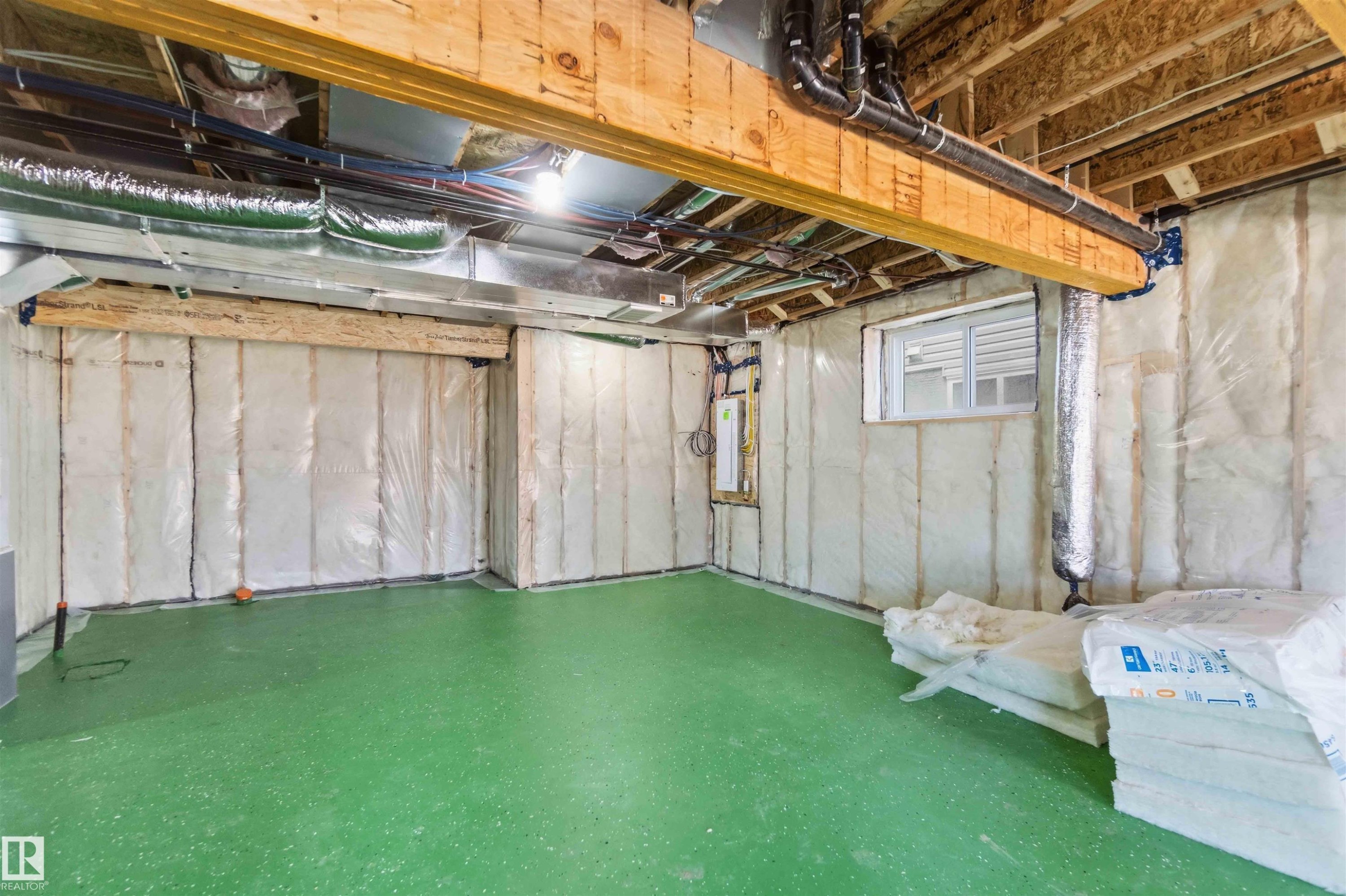 Unfinished basement space featuring exposed wooden beams, a poured concrete floor, insulated walls, and a visible window - 415 Pine Point(E), Leduc, AB - Indoor Photo Showing Basement