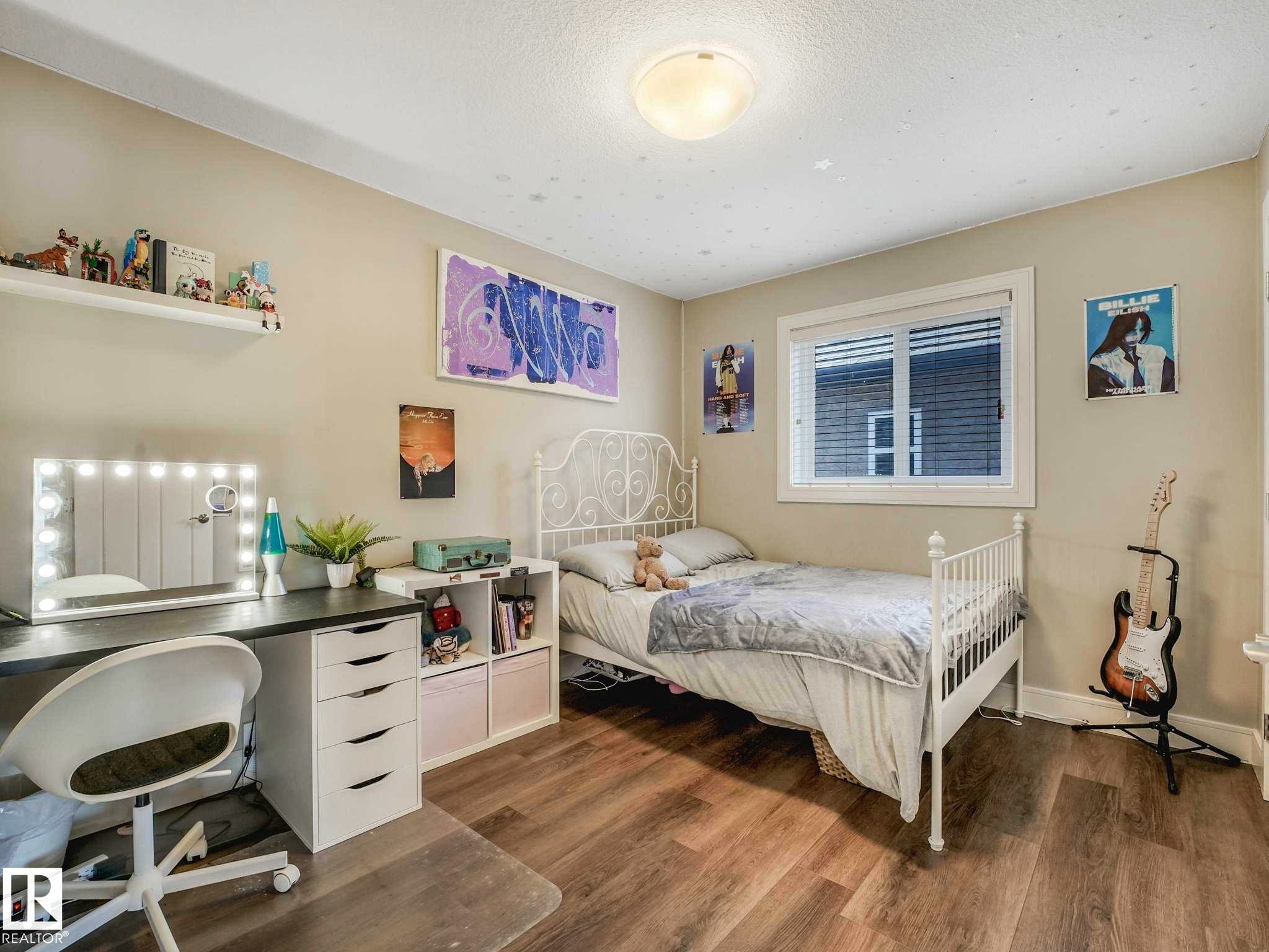 Bedroom featuring wood-finish flooring, a double-pane window, and a built-in floating shelf - 16251 135 Street Nw, Edmonton, AB - Indoor Photo Showing Bedroom