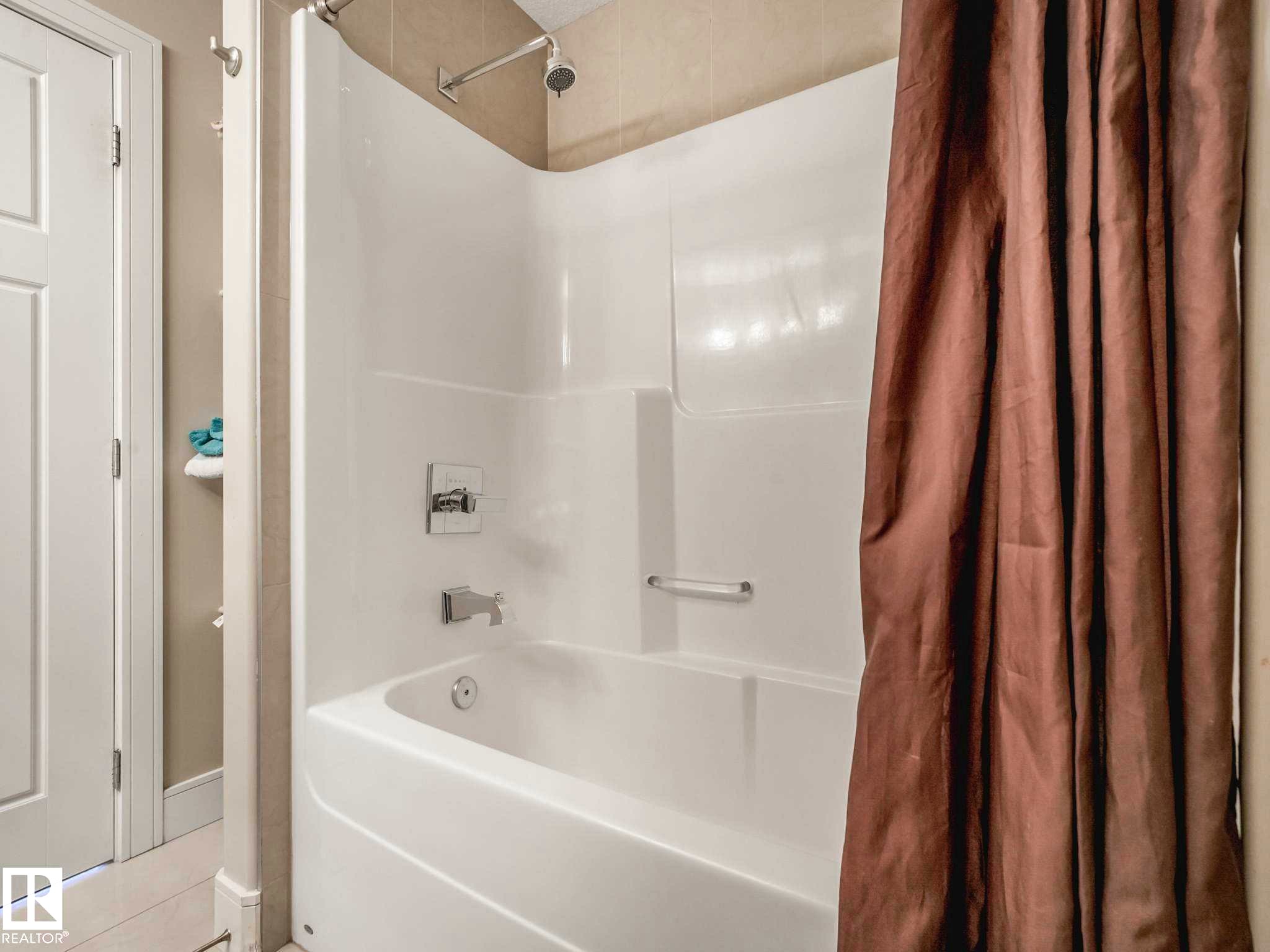 White fiberglass tub and shower combination with chrome fixtures - 16251 135 Street Nw, Edmonton, AB - Indoor Photo Showing Bathroom