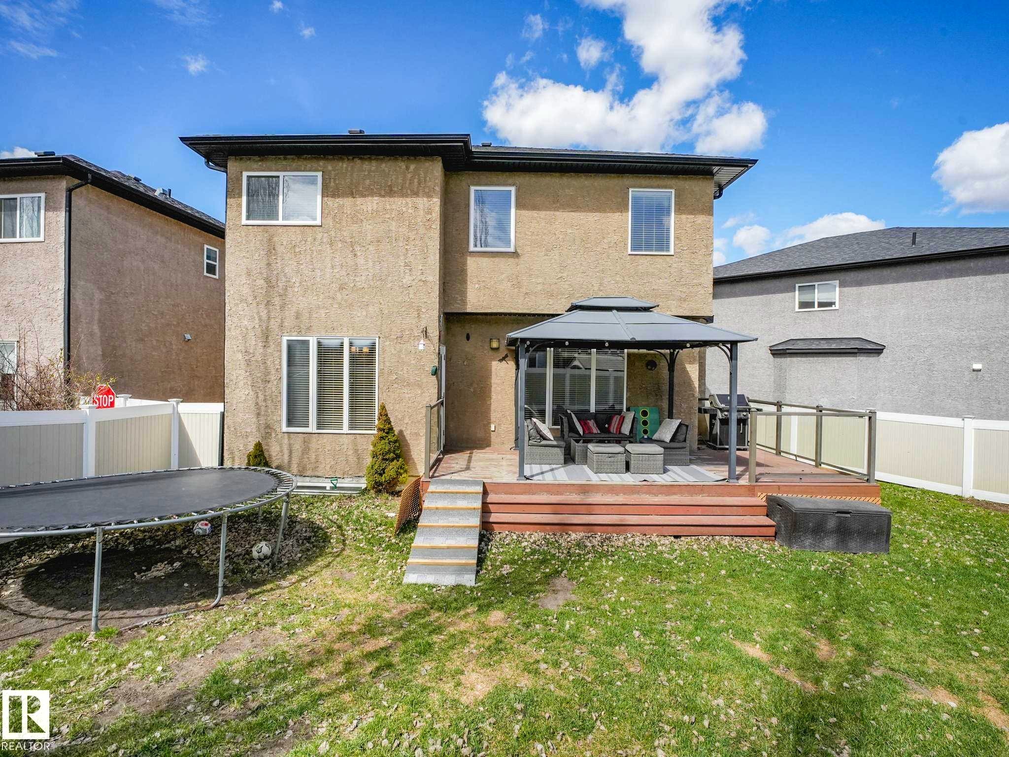 Rear exterior featuring a multi-level deck with gazebo, glass panel railing, and a privacy fence - 16251 135 Street Nw, Edmonton, AB - Outdoor With Deck Patio Veranda