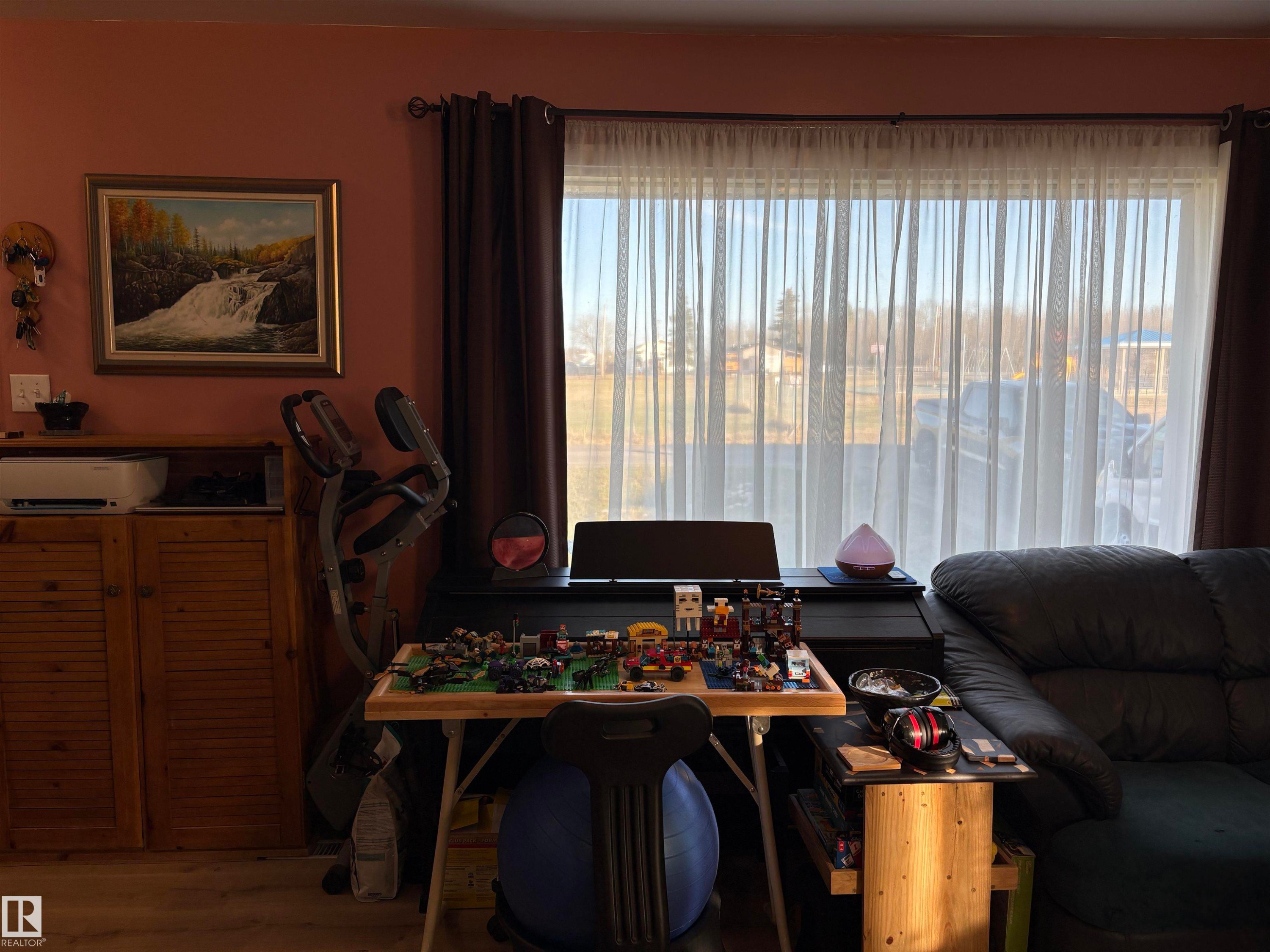 Expansive window dressed with sheer and blackout curtains - 410 Main St, Alcomdale, AB - Indoor