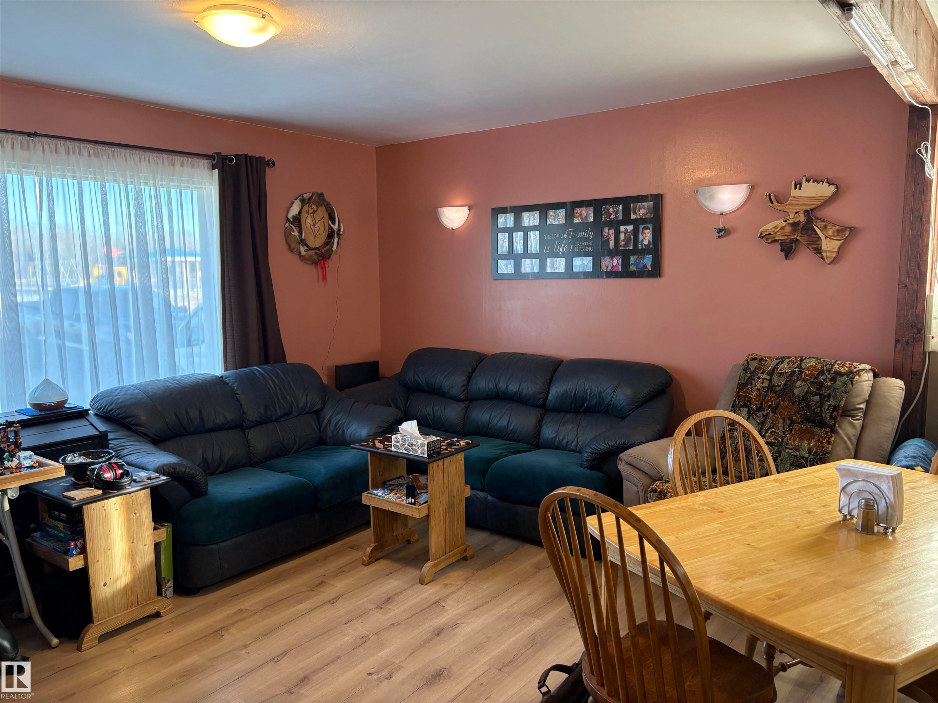 Light wood-finish flooring complements the salmon-toned walls in this interior space - 410 Main St, Alcomdale, AB - Indoor Photo Showing Other Room