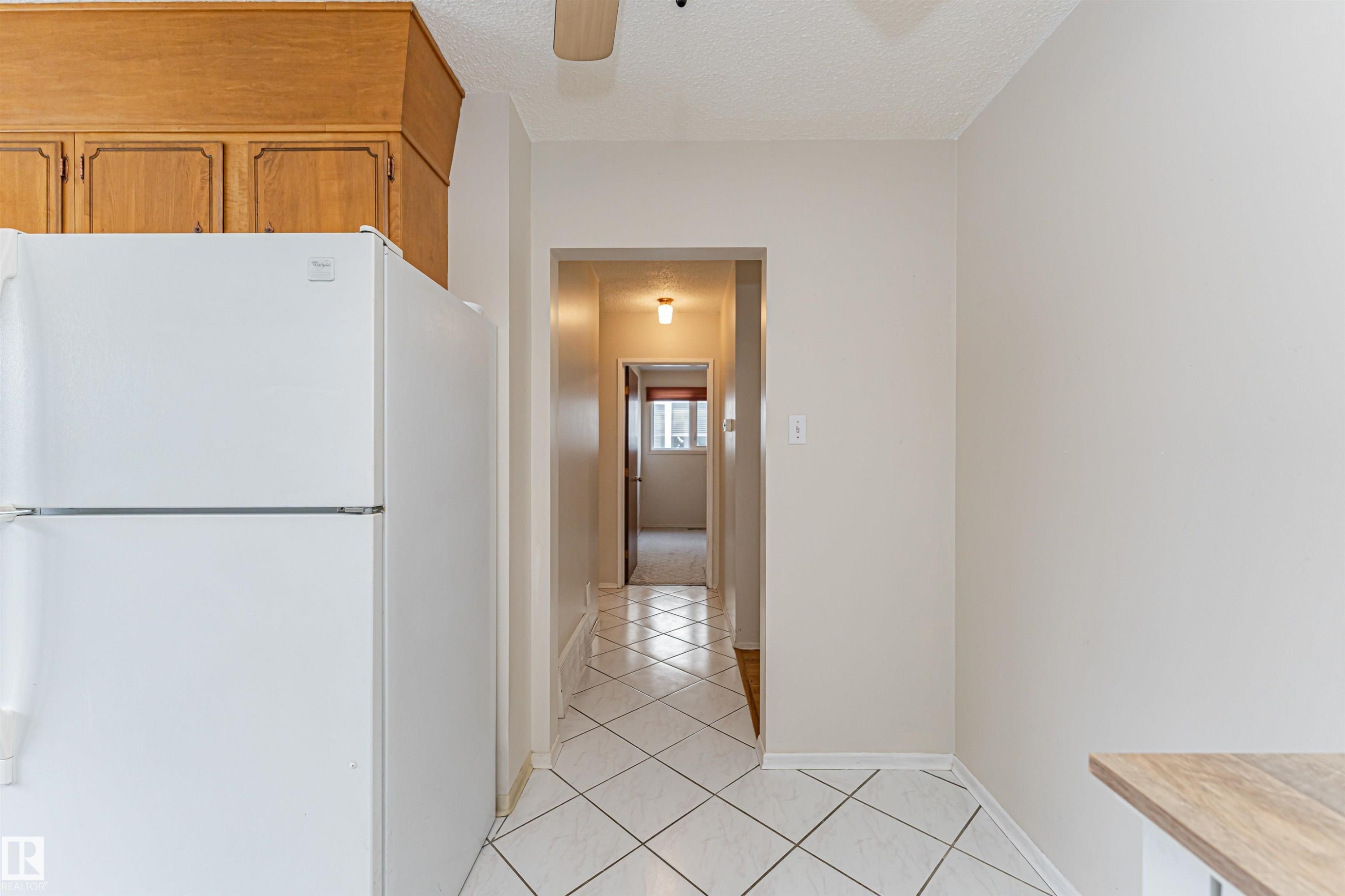 Kitchen area featuring wood cabinetry, white appliances, and light-colored walls - 11423 50 Avenue, Edmonton, AB - Indoor Photo Showing Other Room