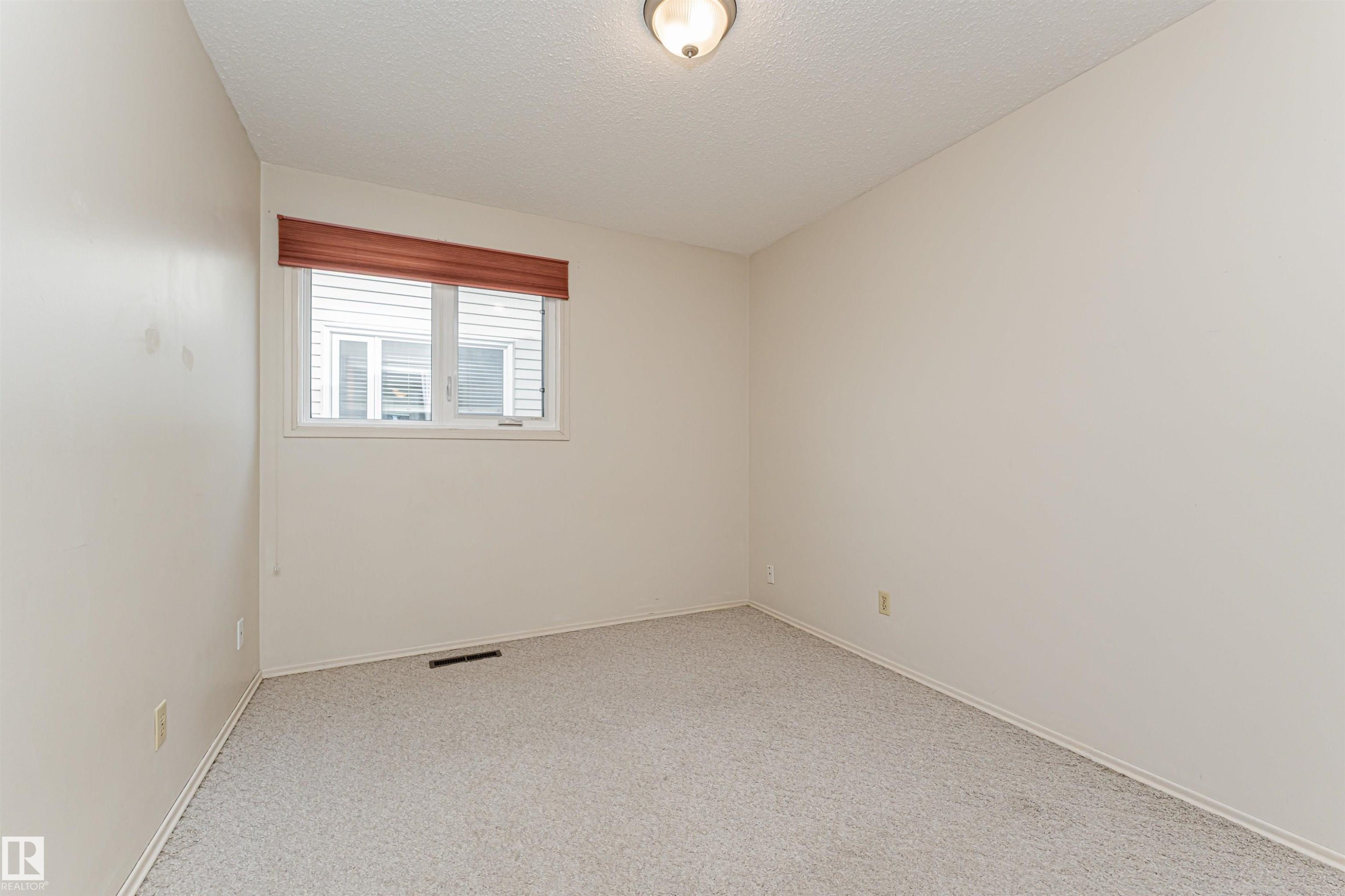 Neutral-toned walls and light-colored carpet flooring - 11423 50 Avenue, Edmonton, AB - Indoor Photo Showing Other Room