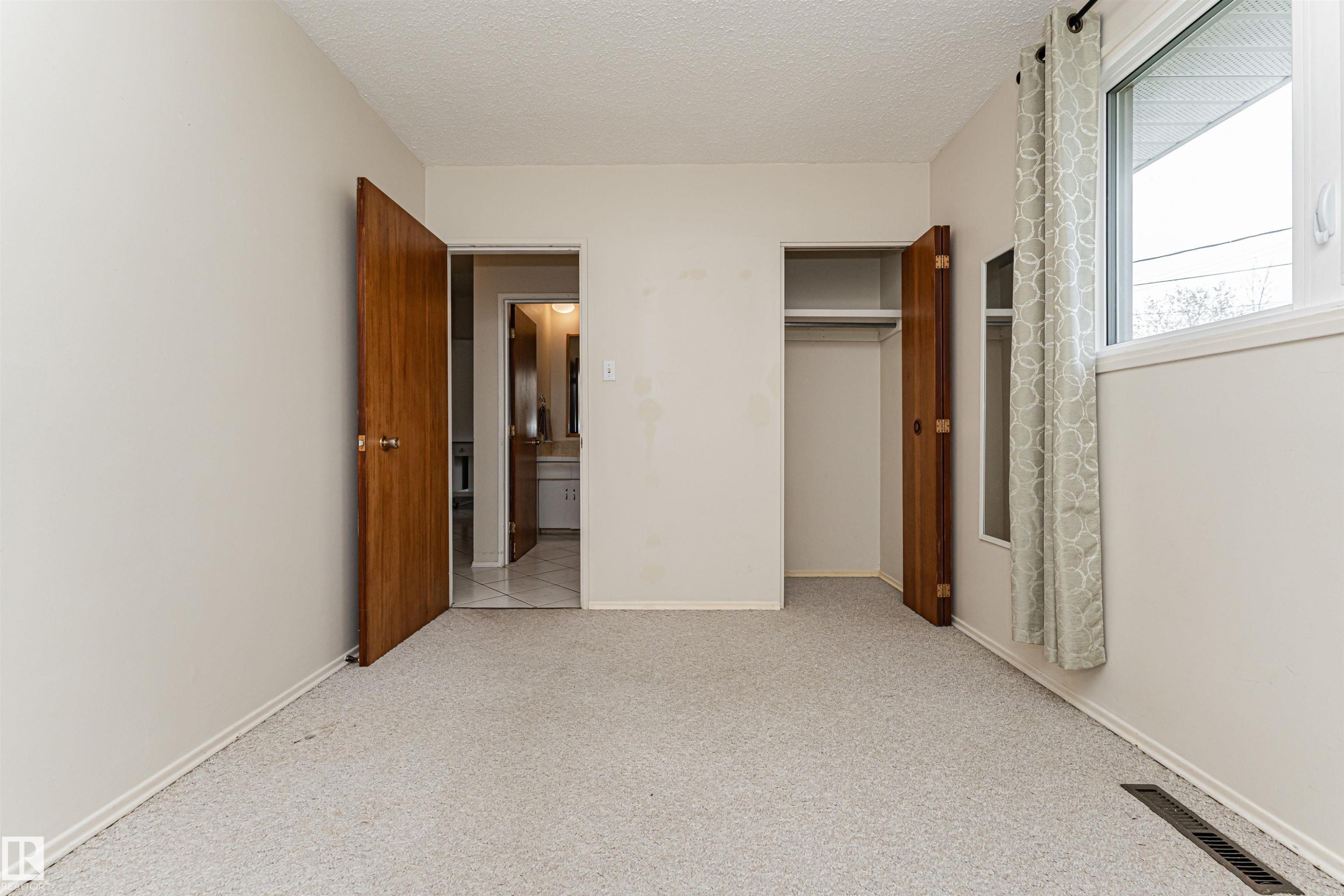 Neutral toned walls with textured ceiling and light-colored carpeting - 11423 50 Avenue, Edmonton, AB - Indoor Photo Showing Other Room