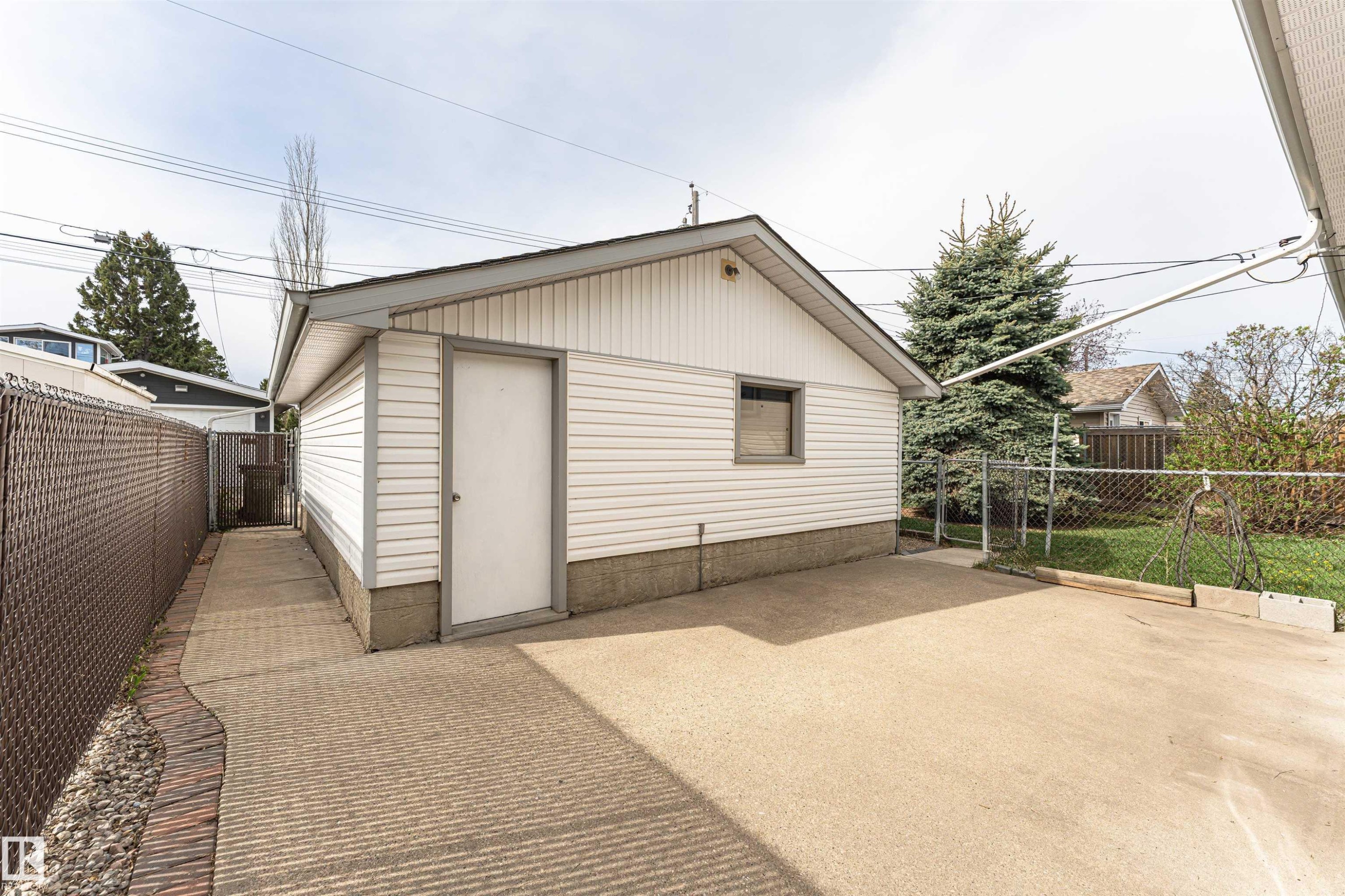 Detached garage with white siding, a side entry door, and a single window - 11423 50 Avenue, Edmonton, AB - Outdoor With Exterior