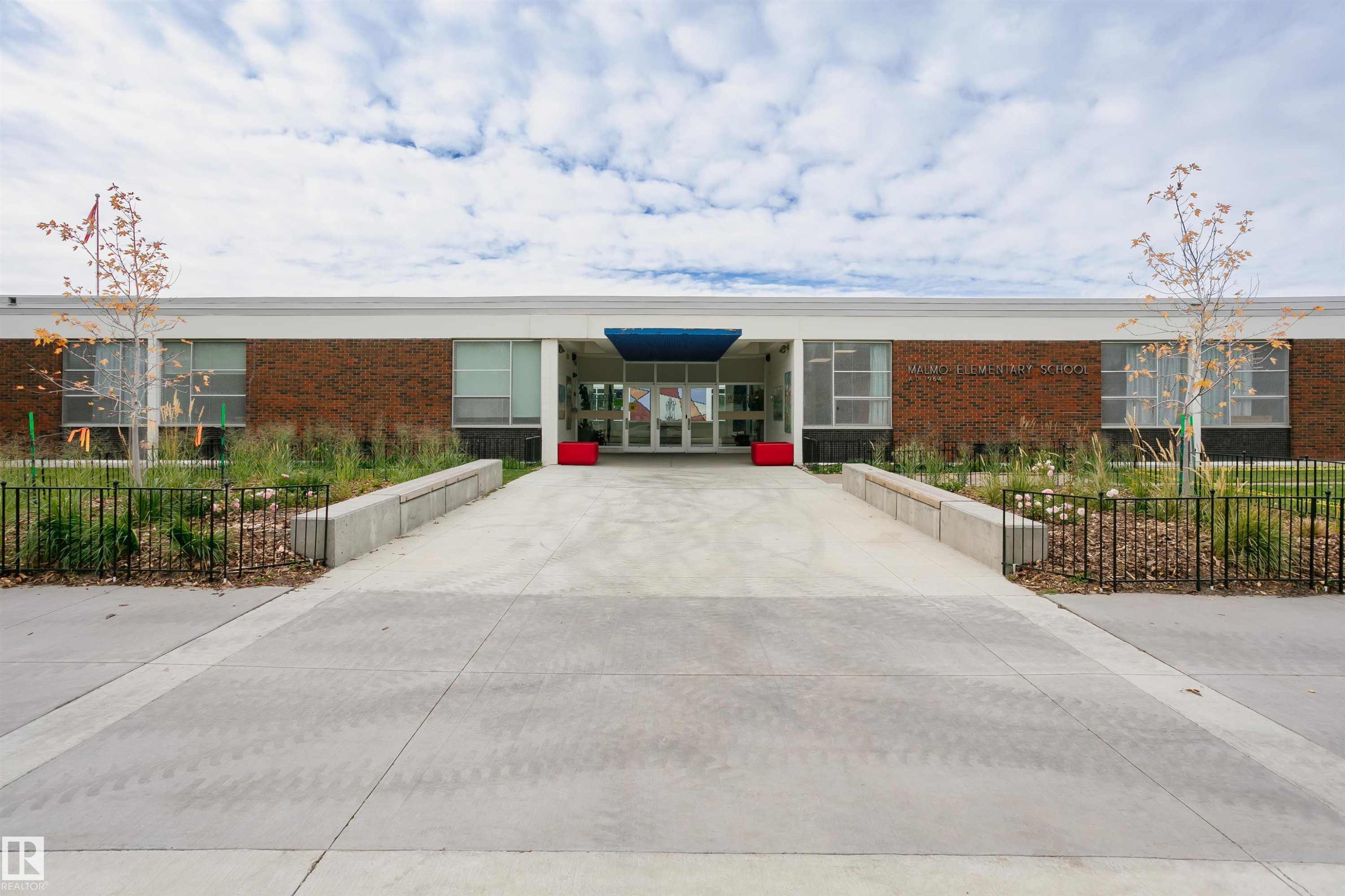 Contemporary commercial facade featuring a prominent concrete entrance ramp and walkway - 11423 50 Avenue, Edmonton, AB - Outdoor