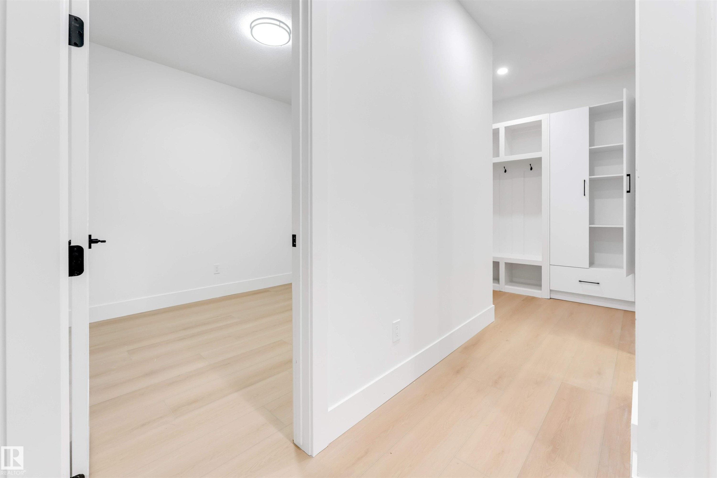 Entryway featuring light-toned flooring, white walls, and built-in storage with shelving and hooks - 4004 35 Street, Beaumont, AB - Indoor Photo Showing Other Room
