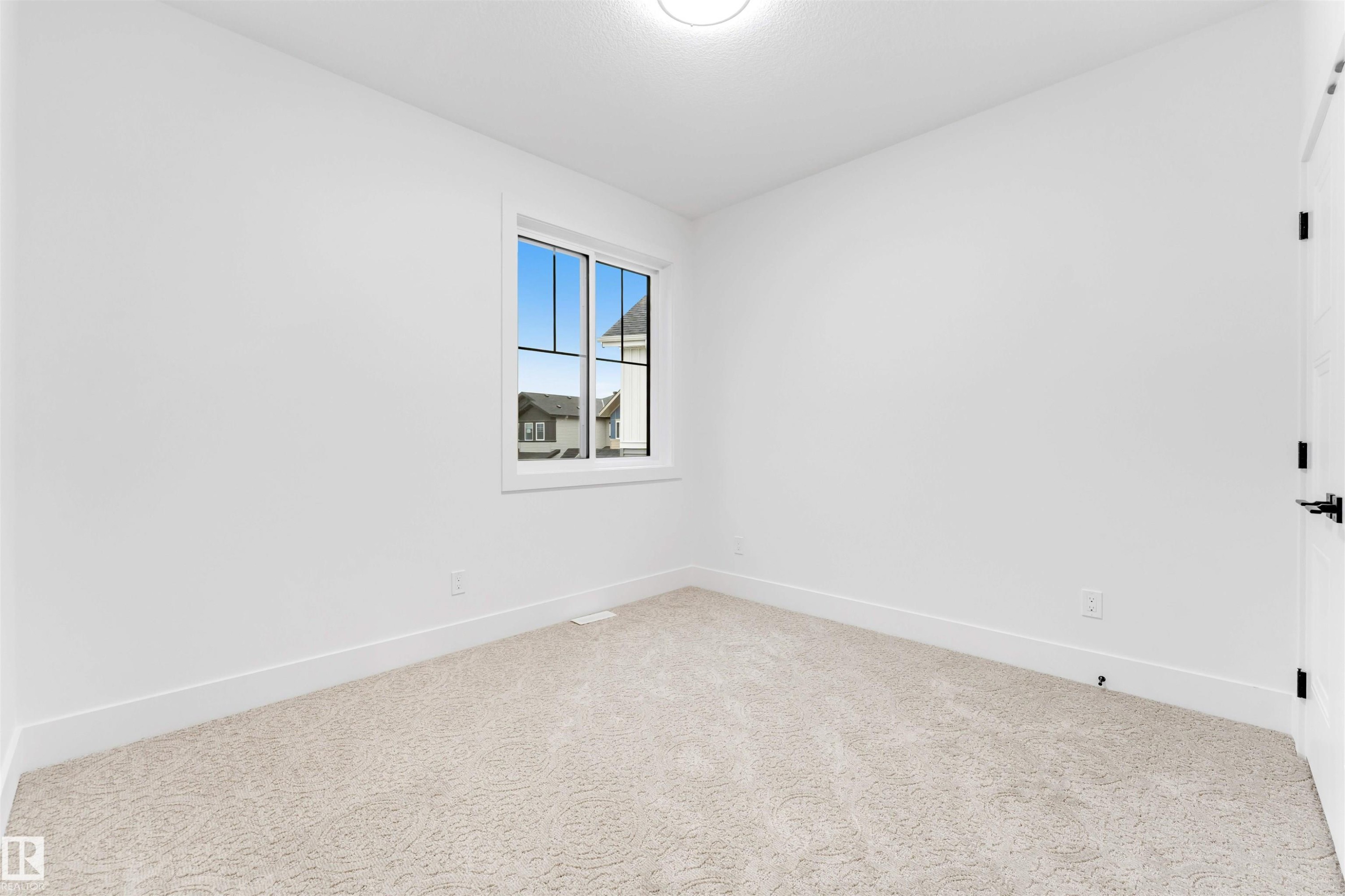 This room features a window providing natural light, white walls, and light-colored carpeting - 4004 35 Street, Beaumont, AB - Indoor Photo Showing Other Room