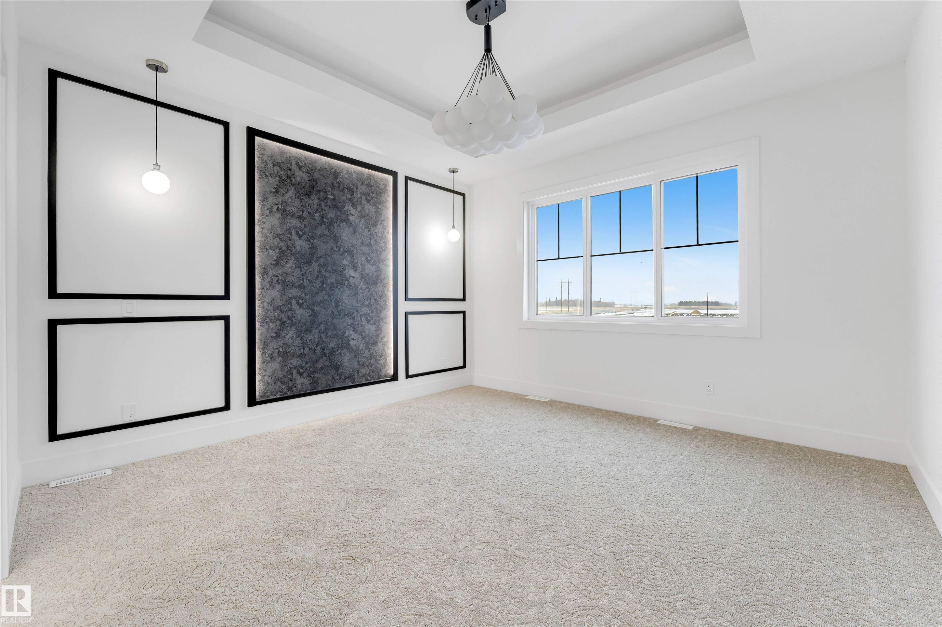 The room features a decorative accent wall with textured paneling and hanging pendant lights, a large window, and patterned carpeting - 4004 35 Street, Beaumont, AB - Indoor Photo Showing Other Room