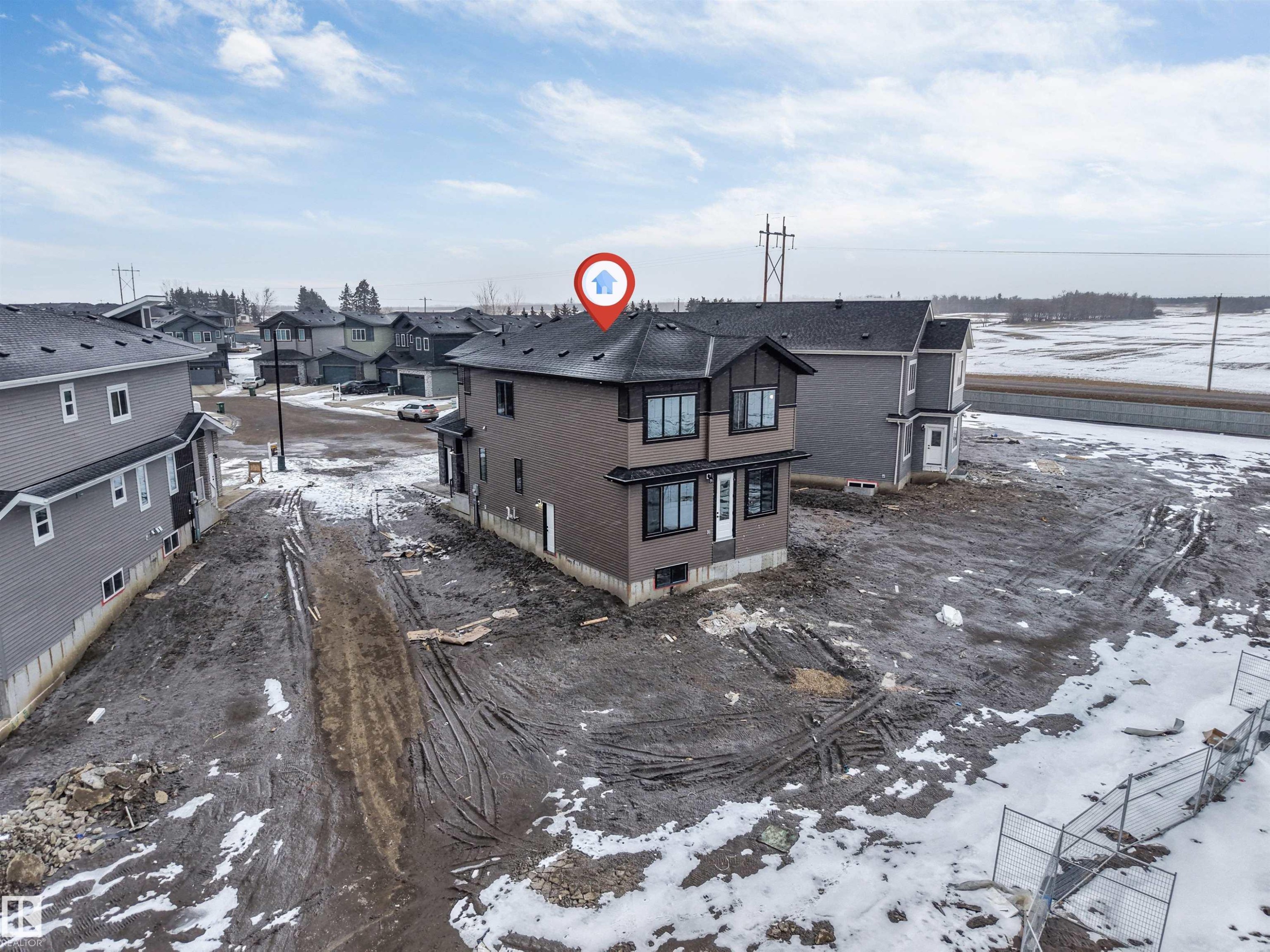 This property features a two-story design with dark siding and multiple windows - 4004 35 Street, Beaumont, AB - Outdoor With View