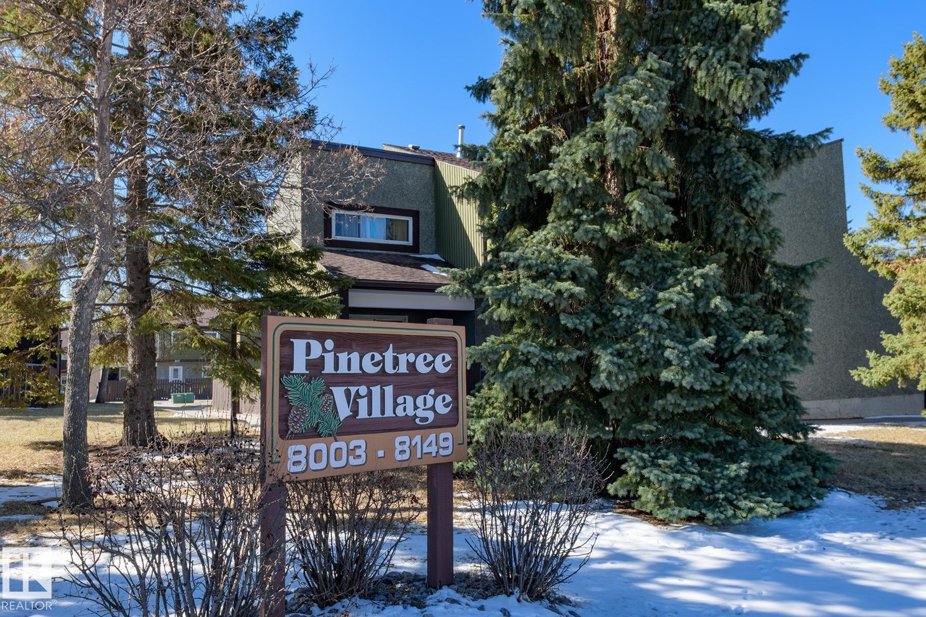 Pinetree Village signage with a multi-level building exterior featuring textured siding - 8039 27 Avenue, Edmonton, AB - Outdoor