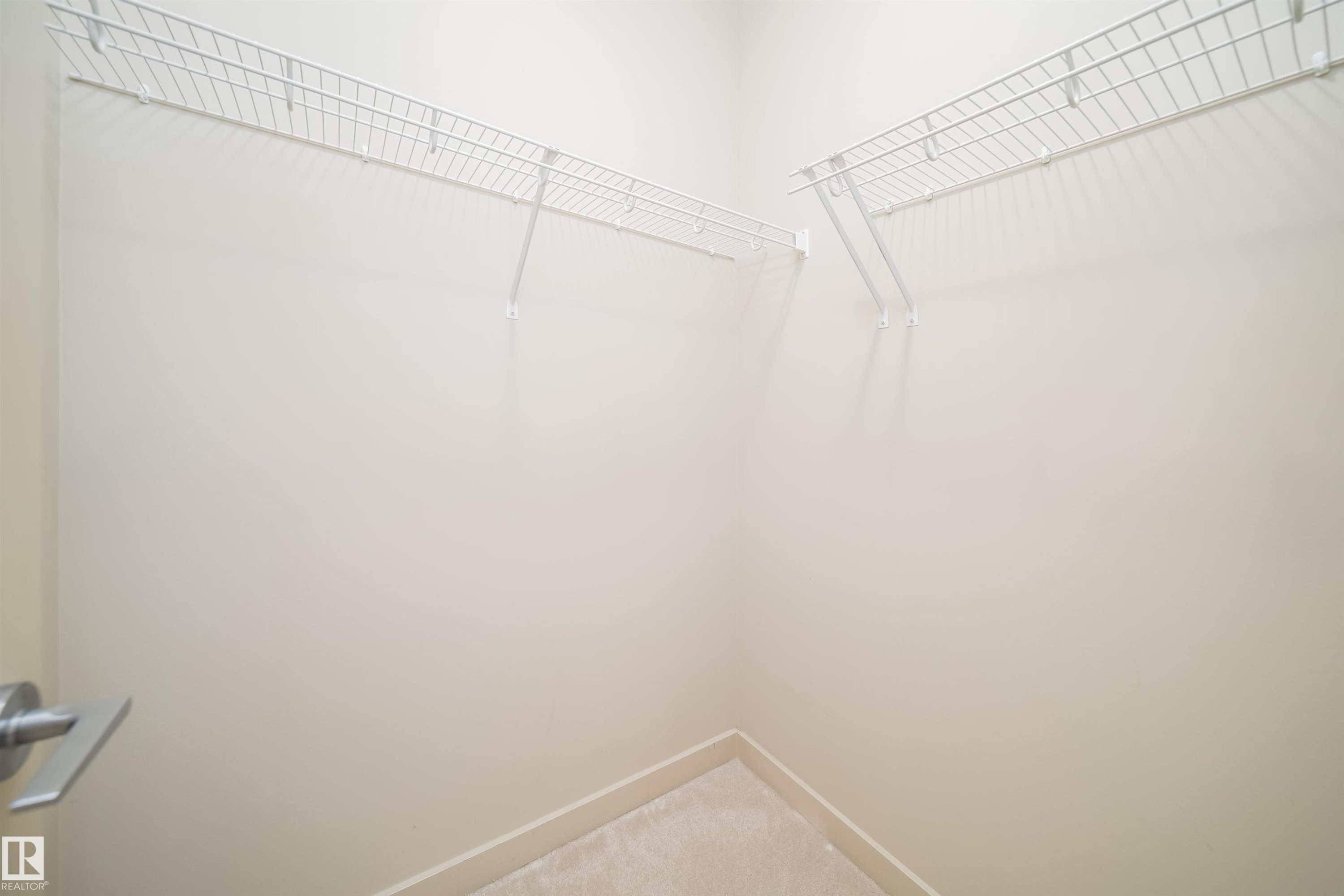 Walk-in closet featuring light-toned walls, wire shelving, and carpeting - 421 4008 Savaryn Drive, Edmonton, AB - Indoor With Storage