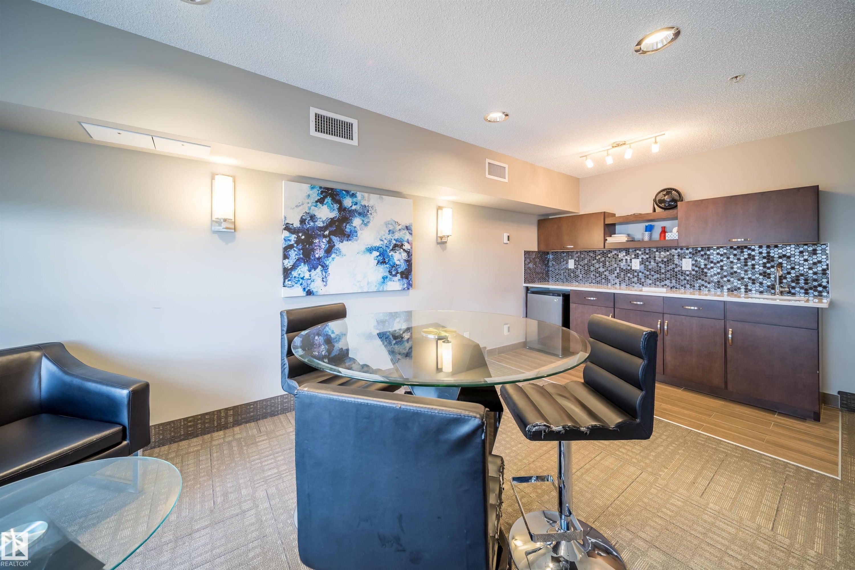 Wet bar area featuring dark wood-finish cabinetry, a mosaic tile backsplash, and a built-in compact refrigerator - 421 4008 Savaryn Drive, Edmonton, AB - Indoor
