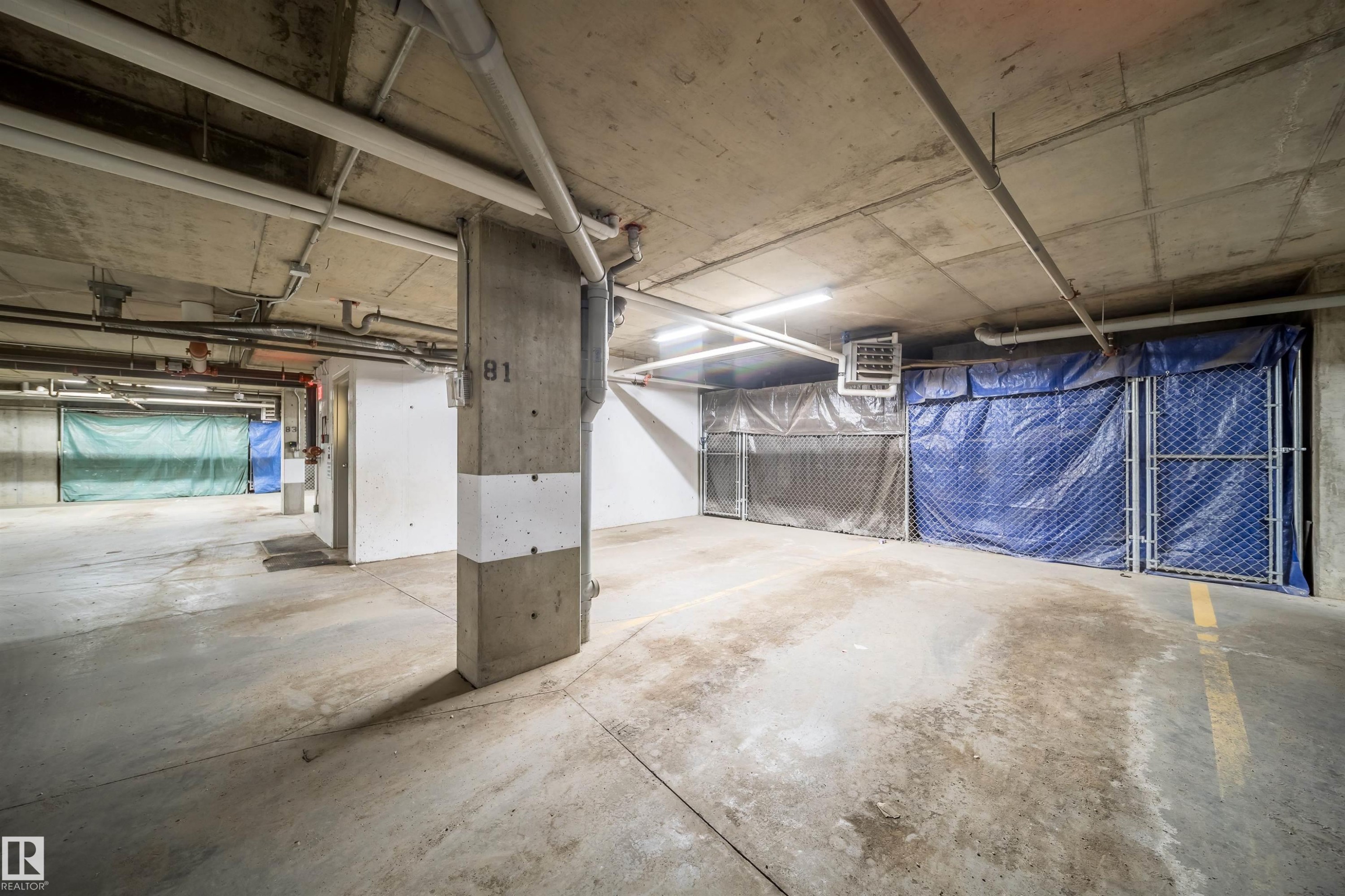 Underground parking area featuring exposed concrete ceilings and support columns - 421 4008 Savaryn Drive, Edmonton, AB - Indoor Photo Showing Garage