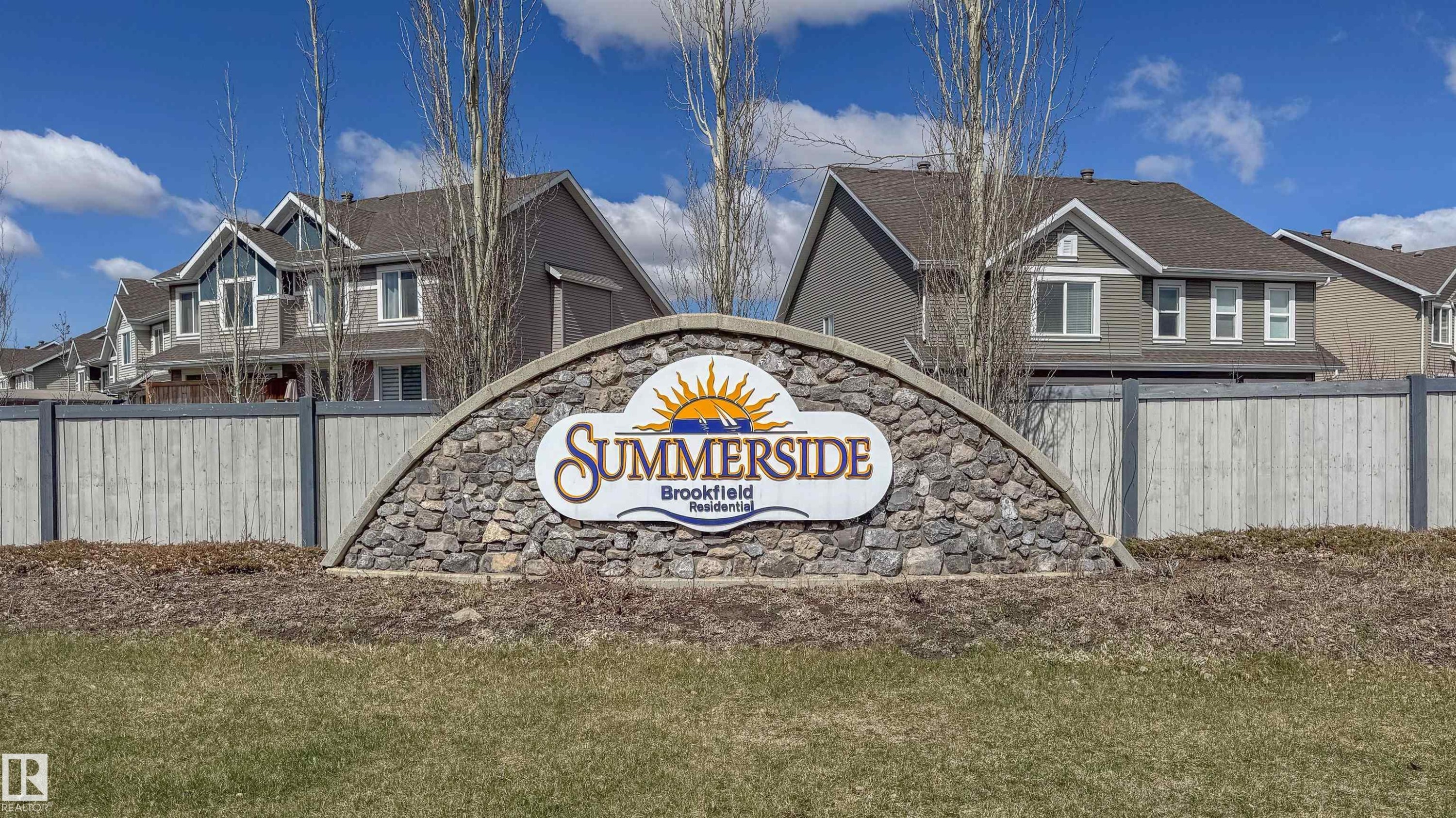 Stone monument sign with arched top and "SUMMERSIDE Brookfield Residential" lettering, surrounded by a wood fence - 421 4008 Savaryn Drive, Edmonton, AB - Outdoor