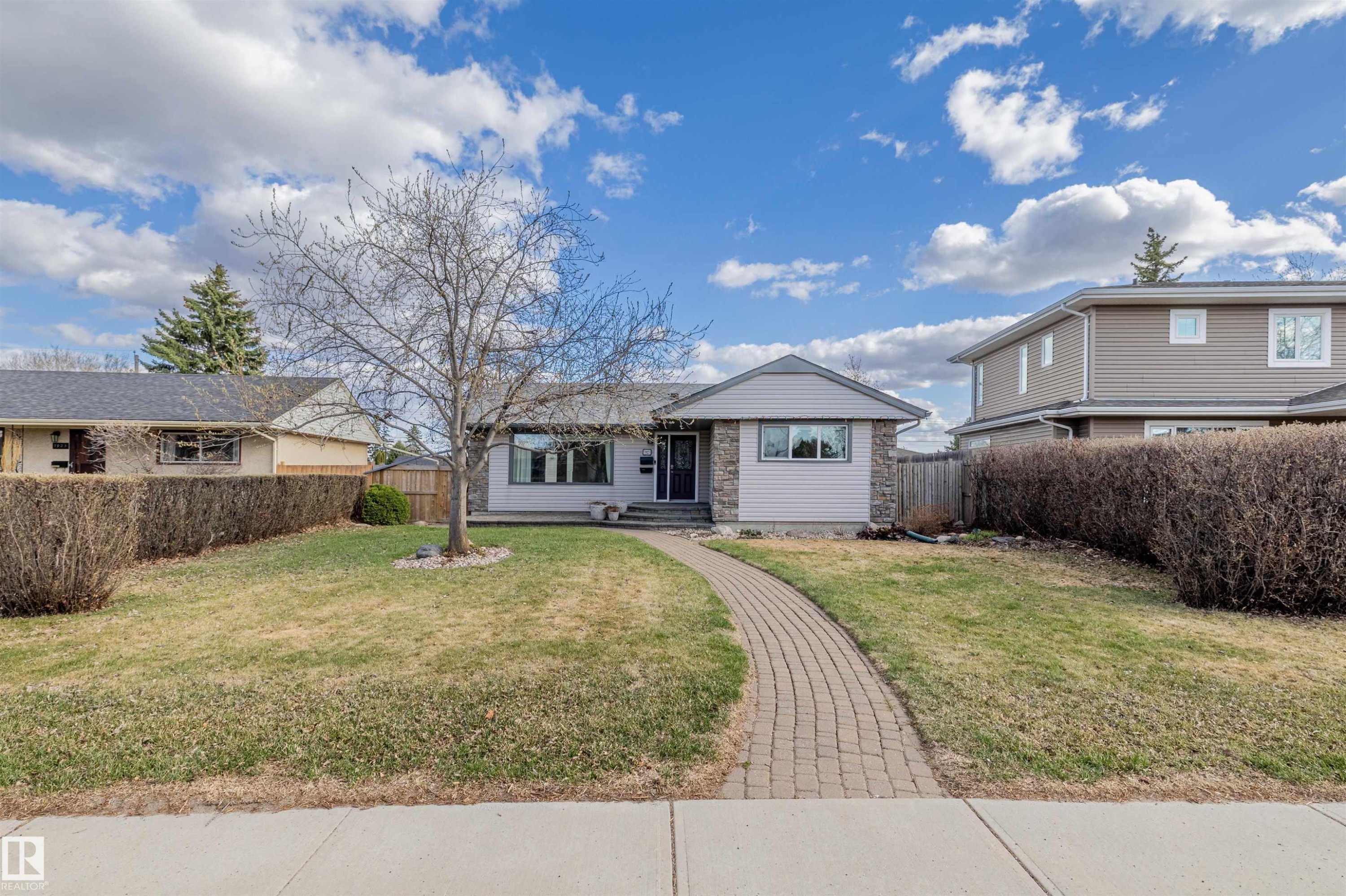 Ranch-style residence featuring a prominent front yard, paved brick walkway, and a mature tree - 7927 71 Avenue, Edmonton, AB - Outdoor