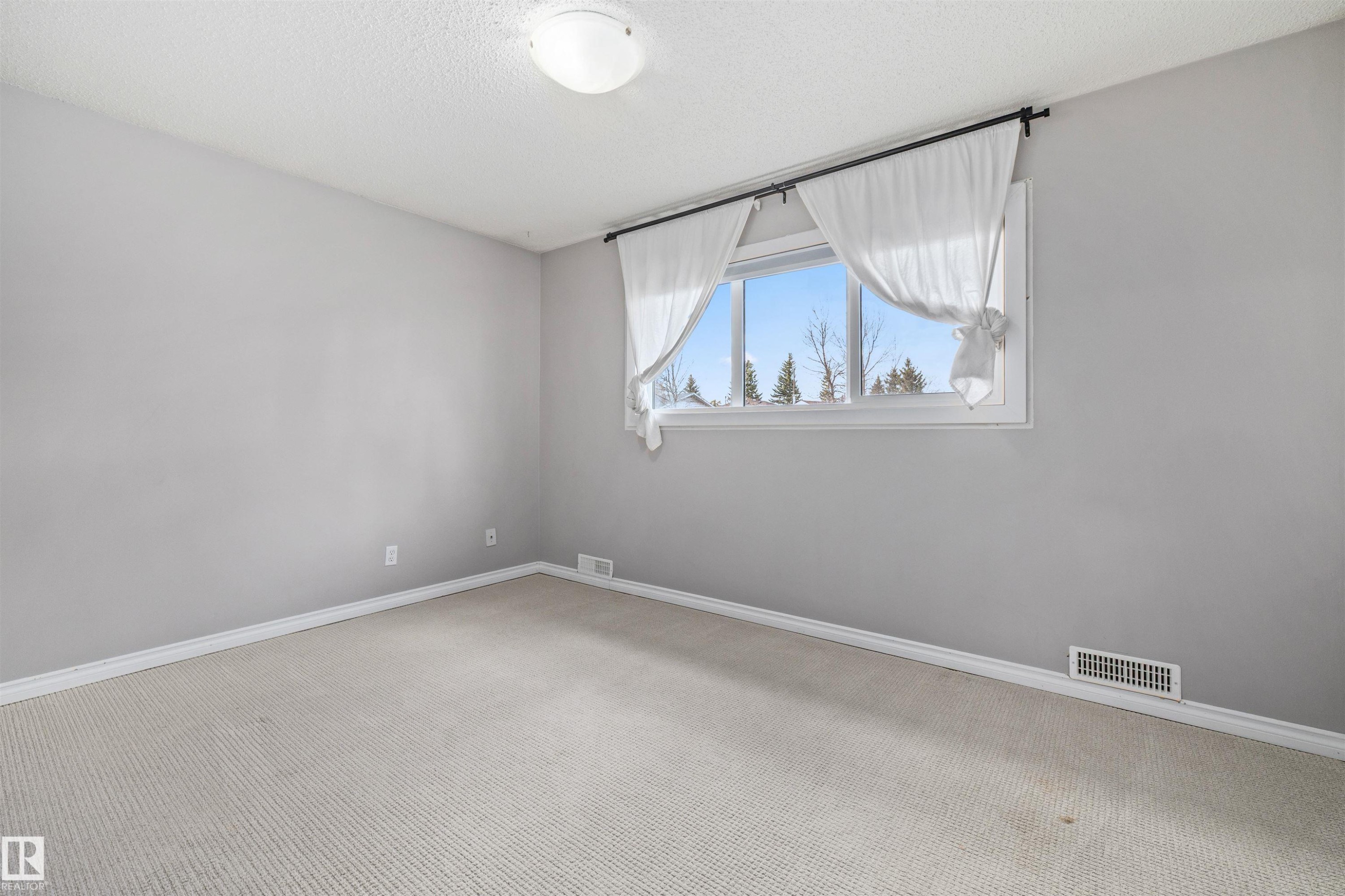 Room featuring light gray walls, white baseboards, and neutral-toned carpet flooring - 7927 71 Avenue, Edmonton, AB - Indoor Photo Showing Other Room