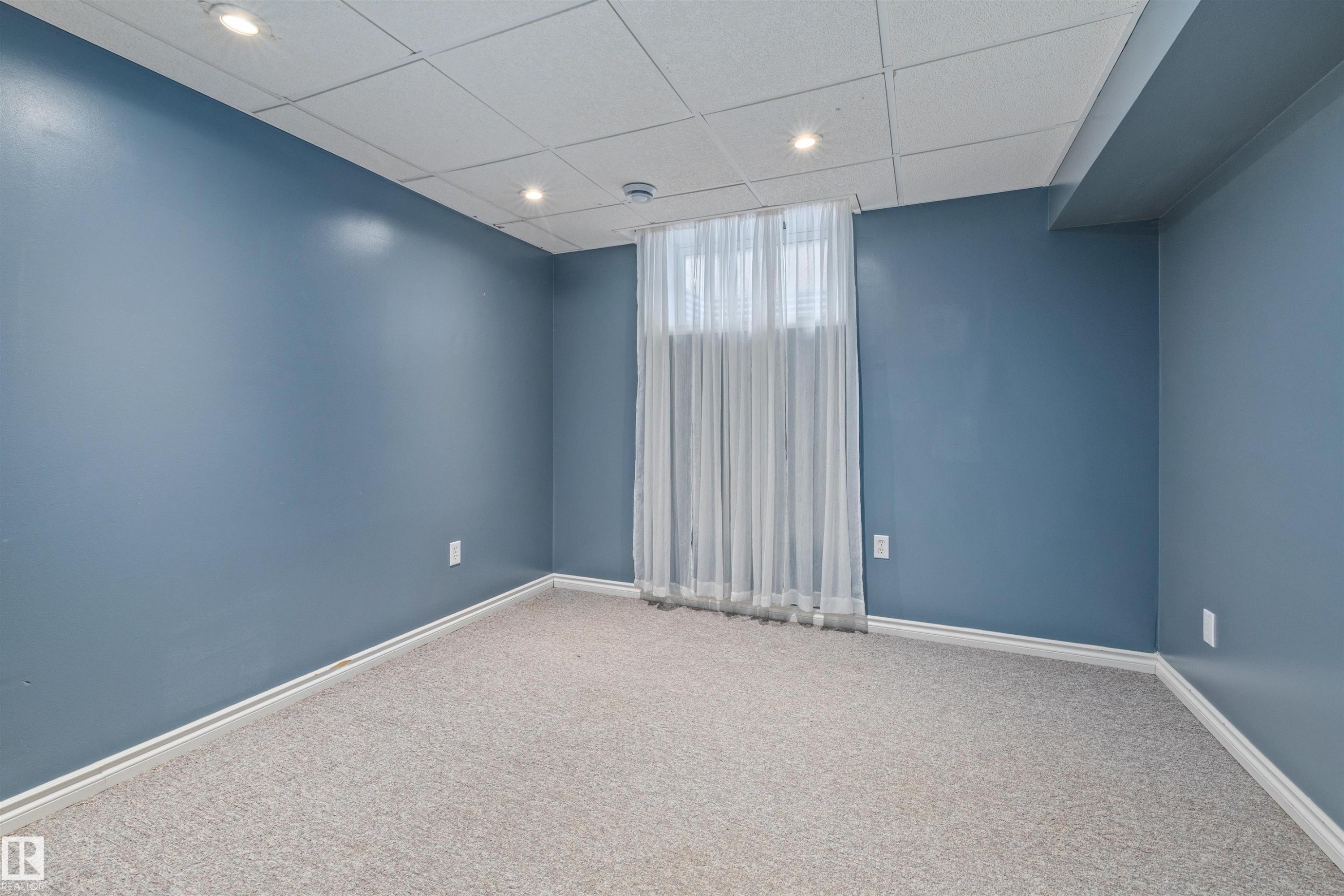 Room featuring textured carpet flooring, blue painted walls, recessed lighting, and a drop ceiling - 7927 71 Avenue, Edmonton, AB - Indoor Photo Showing Other Room
