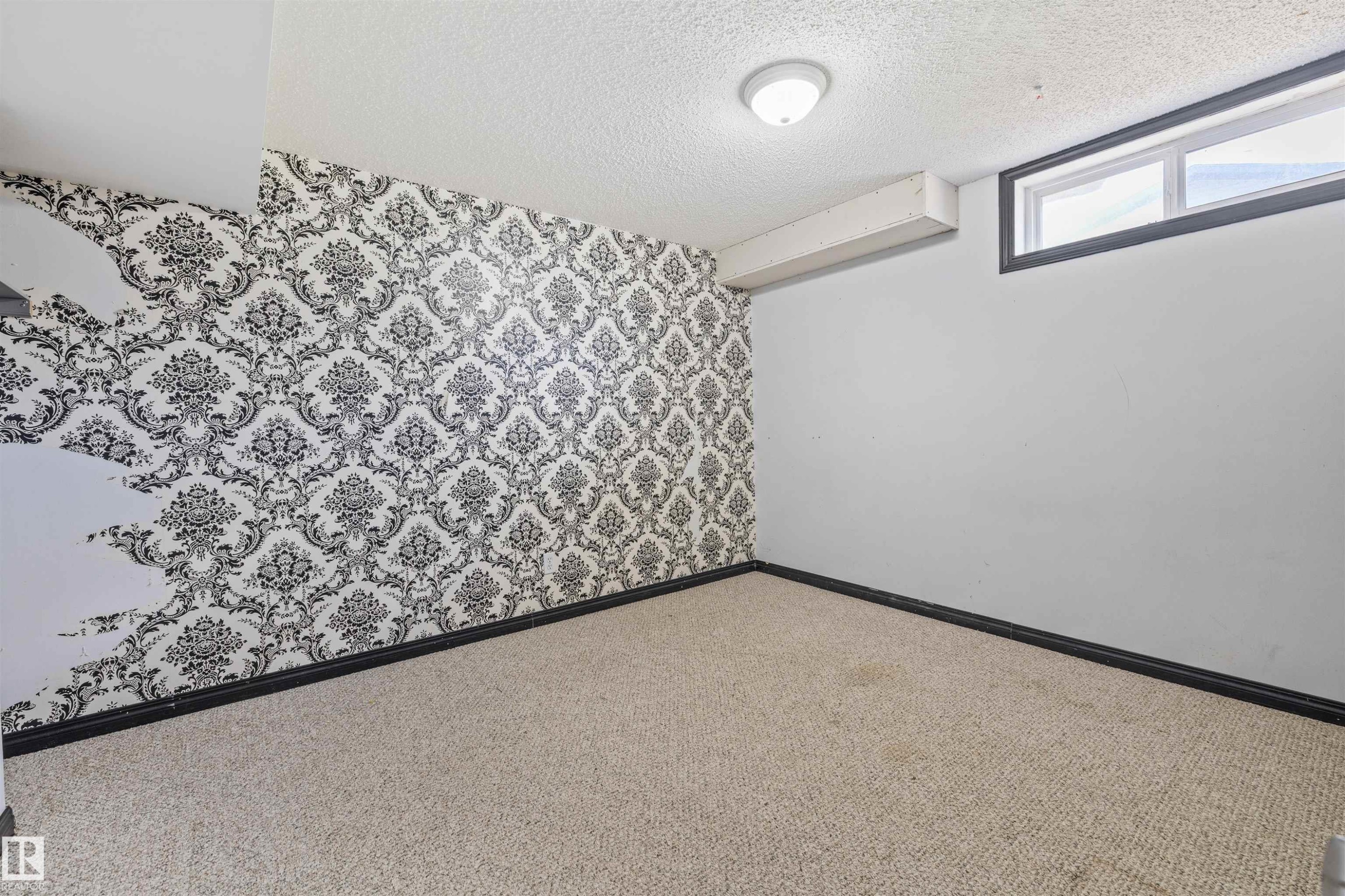 Room featuring a wall with black and white damask wallpaper, a single window, and light-colored carpet flooring - 7927 71 Avenue, Edmonton, AB - Indoor Photo Showing Other Room