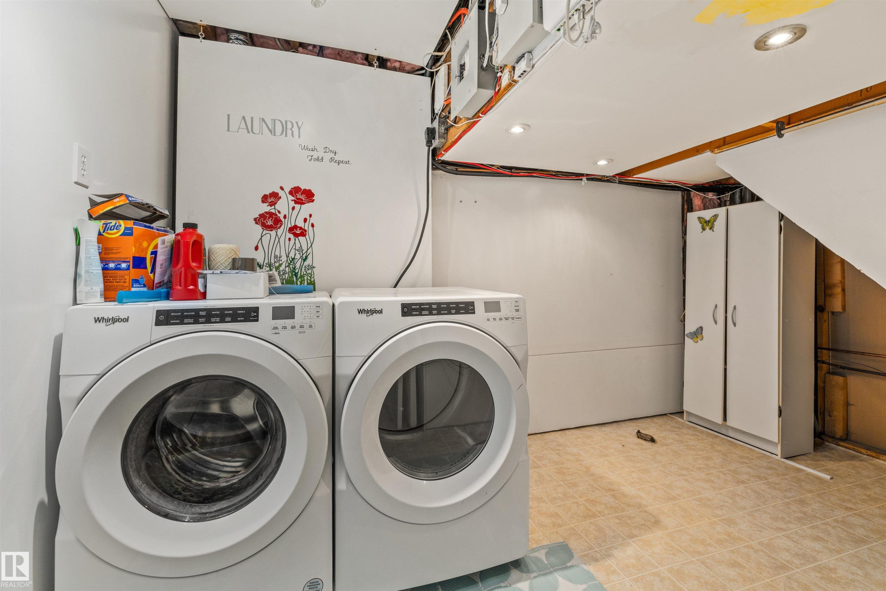 Dedicated laundry area featuring a front-load washer and dryer, tile flooring, recessed lighting, and white storage cabinetry - 7927 71 Avenue, Edmonton, AB - Indoor Photo Showing Laundry Room