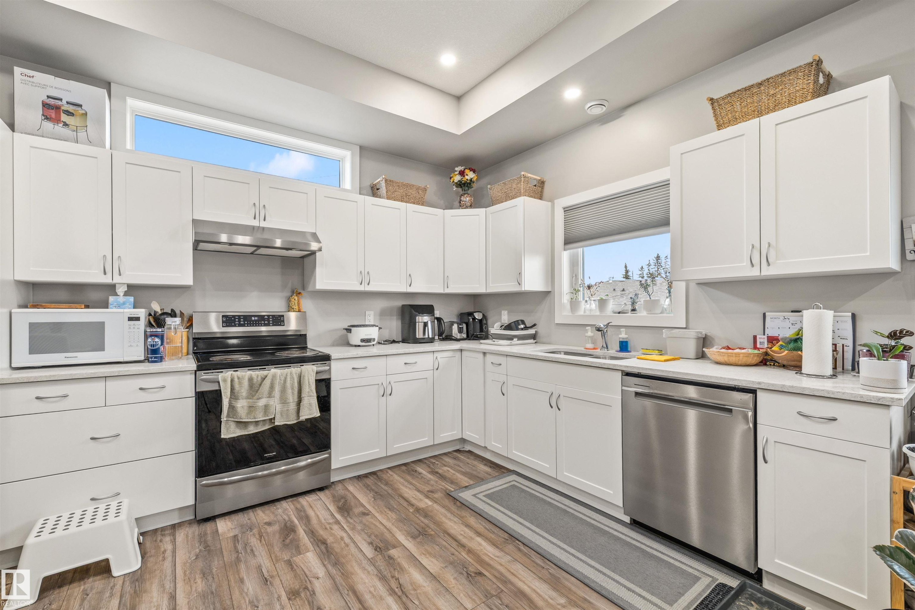 Kitchen featuring white shaker-style cabinetry, quartz countertops, and stainless steel appliances - 7927 71 Avenue, Edmonton, AB - Indoor Photo Showing Kitchen