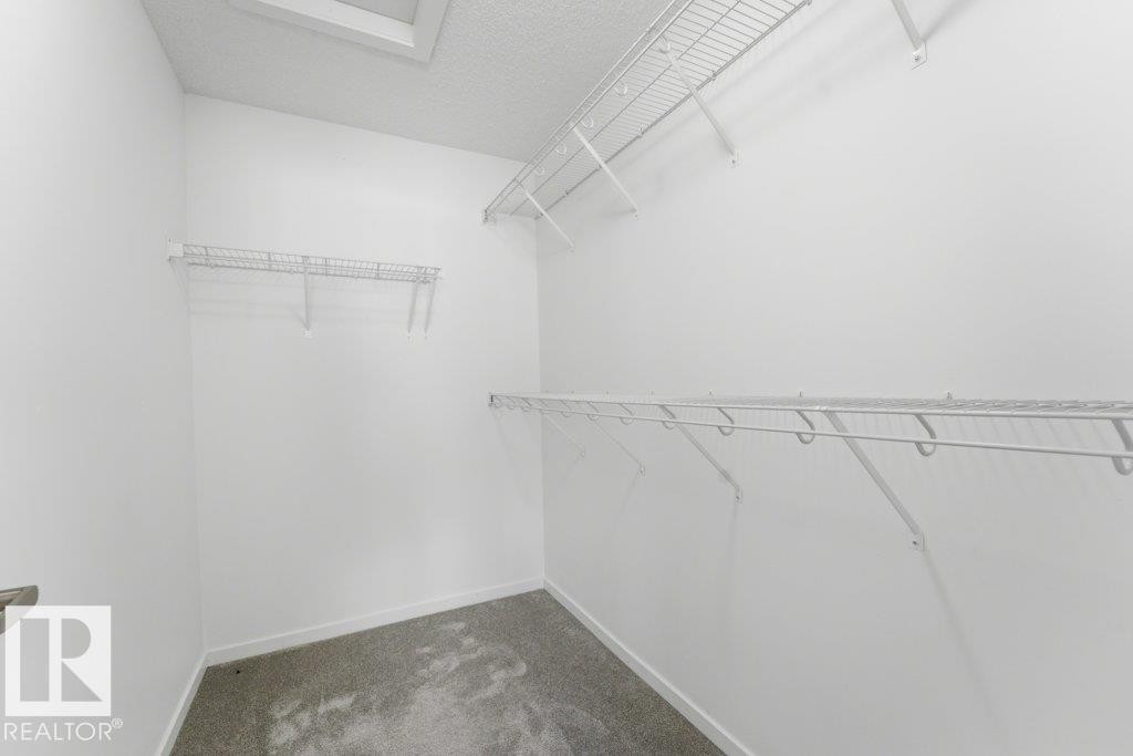 Walk-in closet with carpet flooring, white walls, and white wire shelving - 2011 207 Street, Edmonton, AB - Indoor With Storage