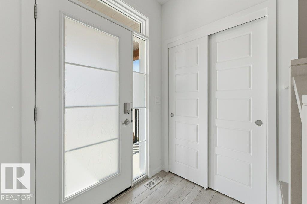 Entryway featuring a contemporary front door with frosted glass panels, a full-length sidelight, and an overhead transom window - 2011 207 Street, Edmonton, AB - Indoor Photo Showing Other Room