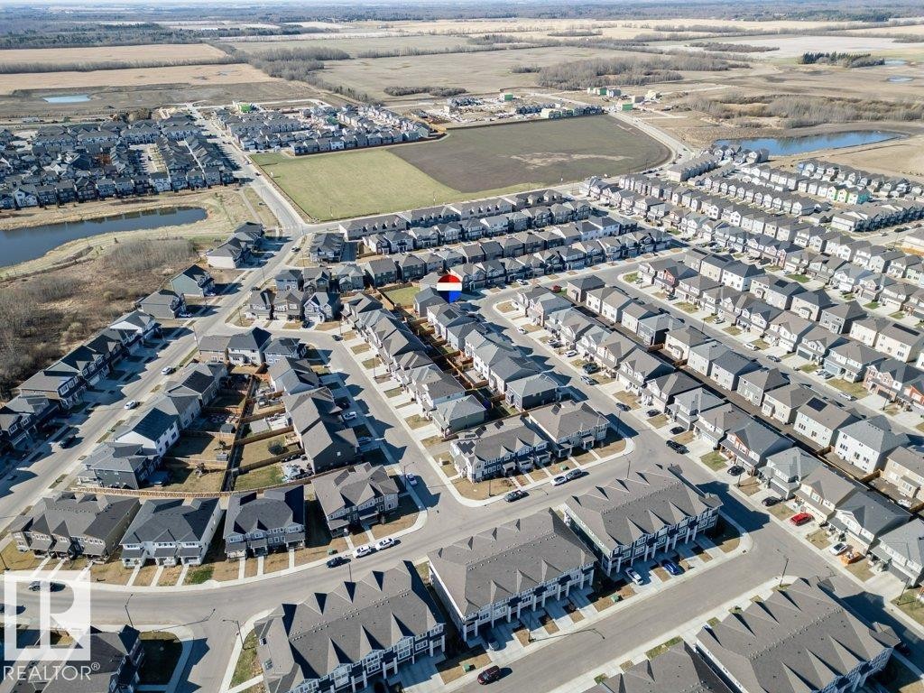 Expansive residential development featuring a structured street grid, uniform housing styles, varied rooflines, and adjacent undeveloped land - 2011 207 Street, Edmonton, AB - Outdoor With View