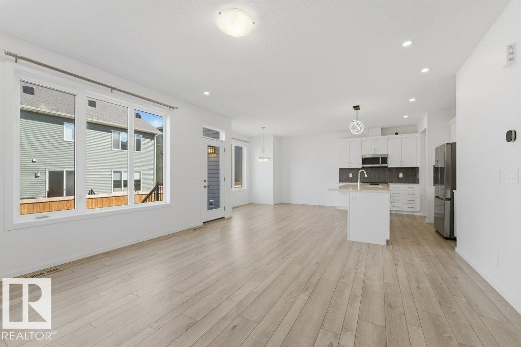 Open-concept living space with light wood-finish flooring - 2011 207 Street, Edmonton, AB - Indoor Photo Showing Kitchen
