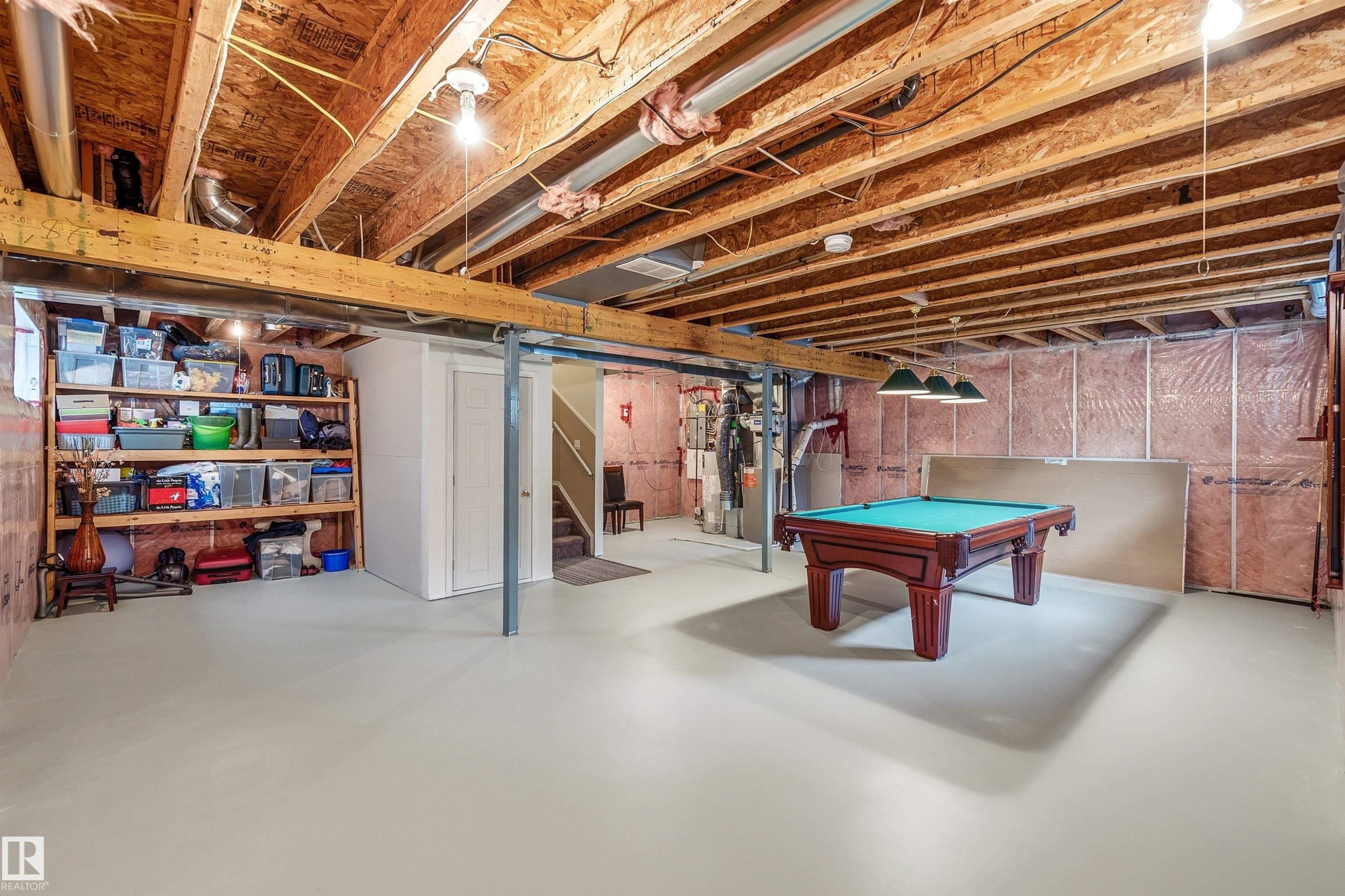 Expansive unfinished basement featuring exposed wood joists, a painted concrete floor, and insulated perimeter walls - 2340 Hagen Link, Edmonton, AB - Indoor Photo Showing Basement
