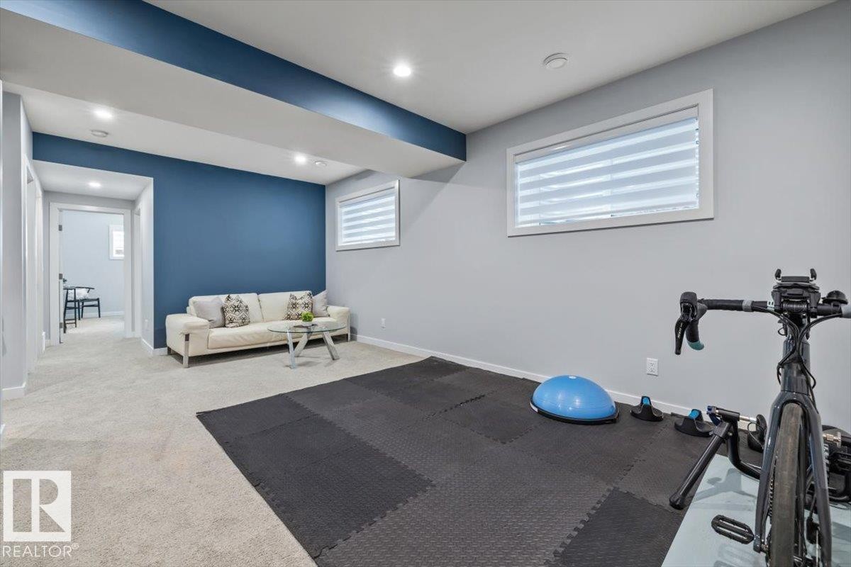 Spacious room featuring light gray carpeting and a contrasting accent wall - 11245 64 Street, Edmonton, AB - Indoor