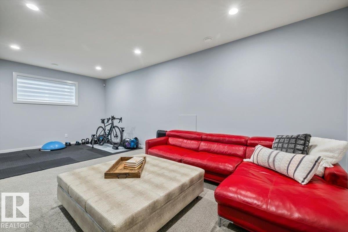 Recessed ceiling lighting illuminates the spacious room with light gray walls and carpeted flooring - 11245 64 Street, Edmonton, AB - Indoor