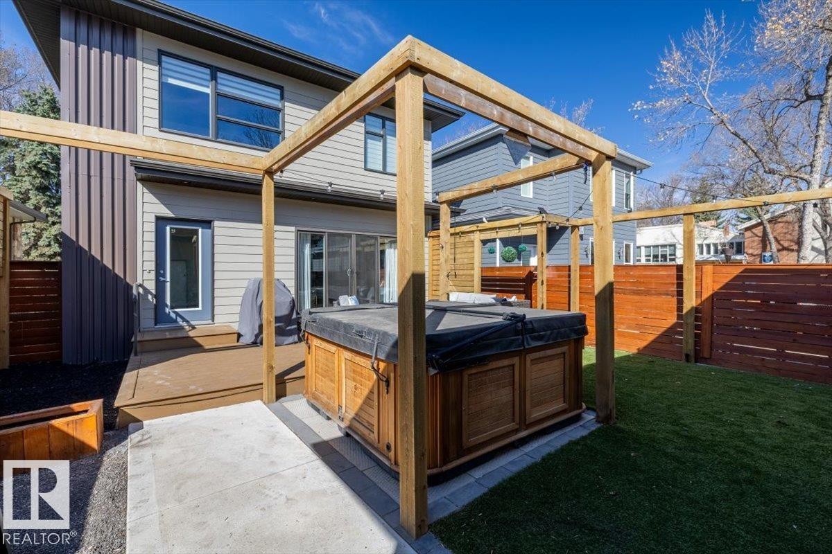 Outdoor spa framed by a wooden pergola, set on a concrete patio - 11245 64 Street, Edmonton, AB - Outdoor With Deck Patio Veranda